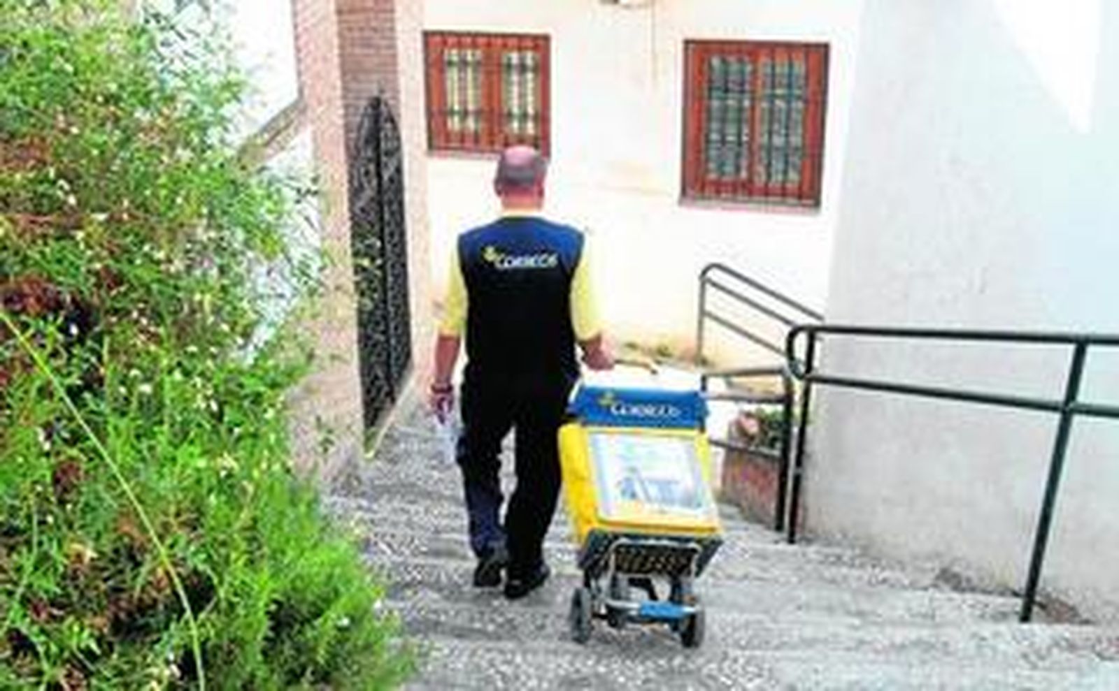 1. Antonio Antequera desciende con su carro por una de los callejones del barrio del Albaicín. 2. El buzón de la Alhambra, con el emblemático león. 4. Antonio Antequera, que lleva 25 años en Correos, revisa la correspondencia antes de echarla en los buzones. 5. Beatriz López, que lleva seis años como cartera, es la encargada de los buzones de la Alhambra y del barrio del Barranco del Abogado.