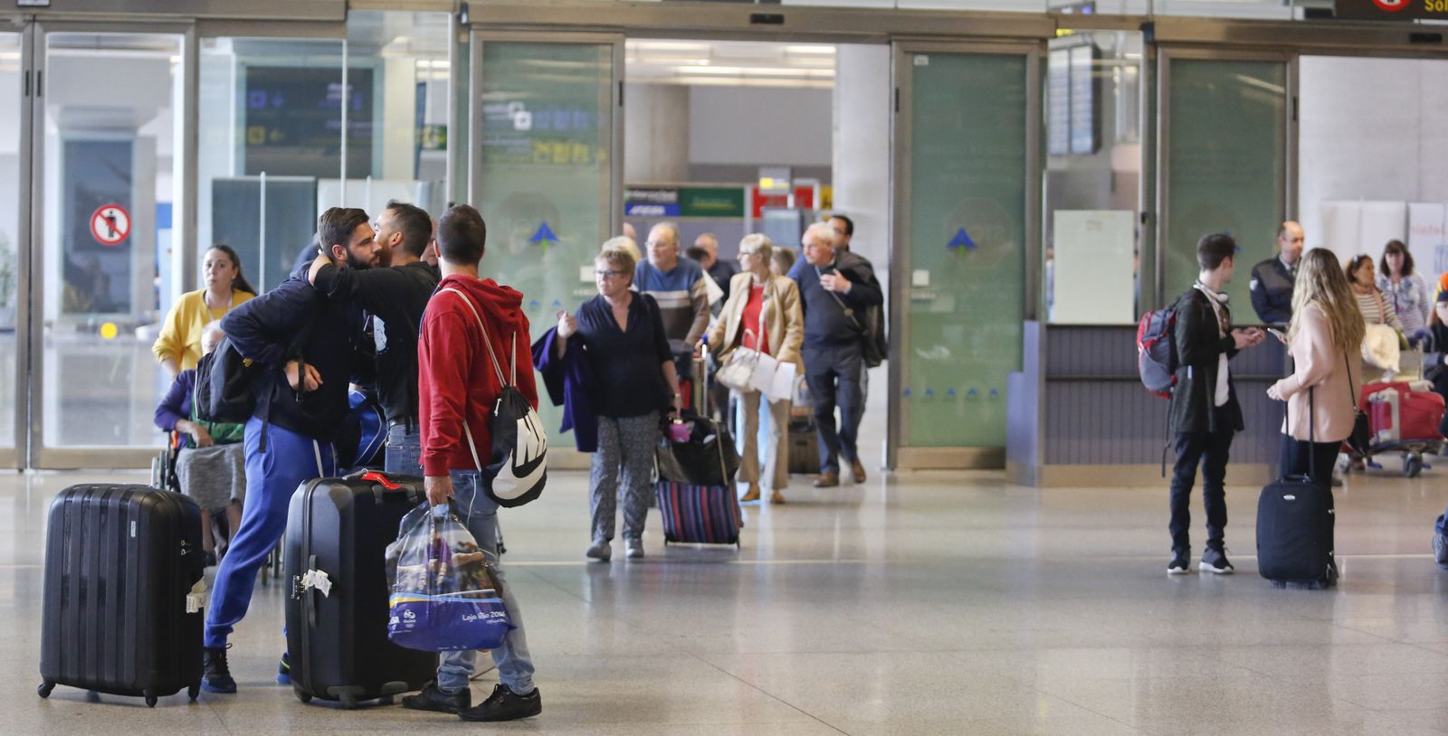 Unos jóvenes se saludan en el aeropuerto de Málaga.