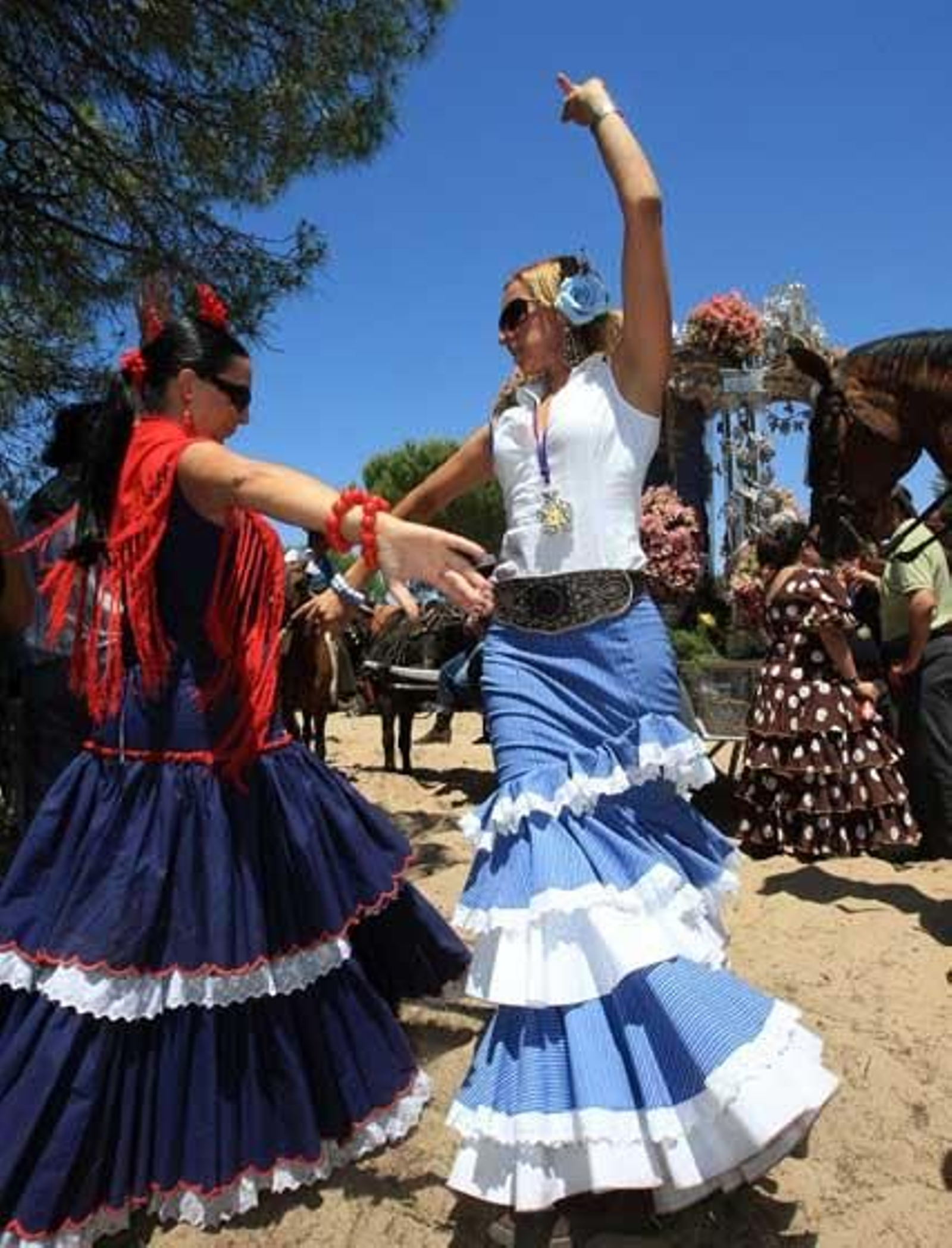 Dos rocieras bailando ayer unas sevillanas.

Foto: Juan Carlos Toro