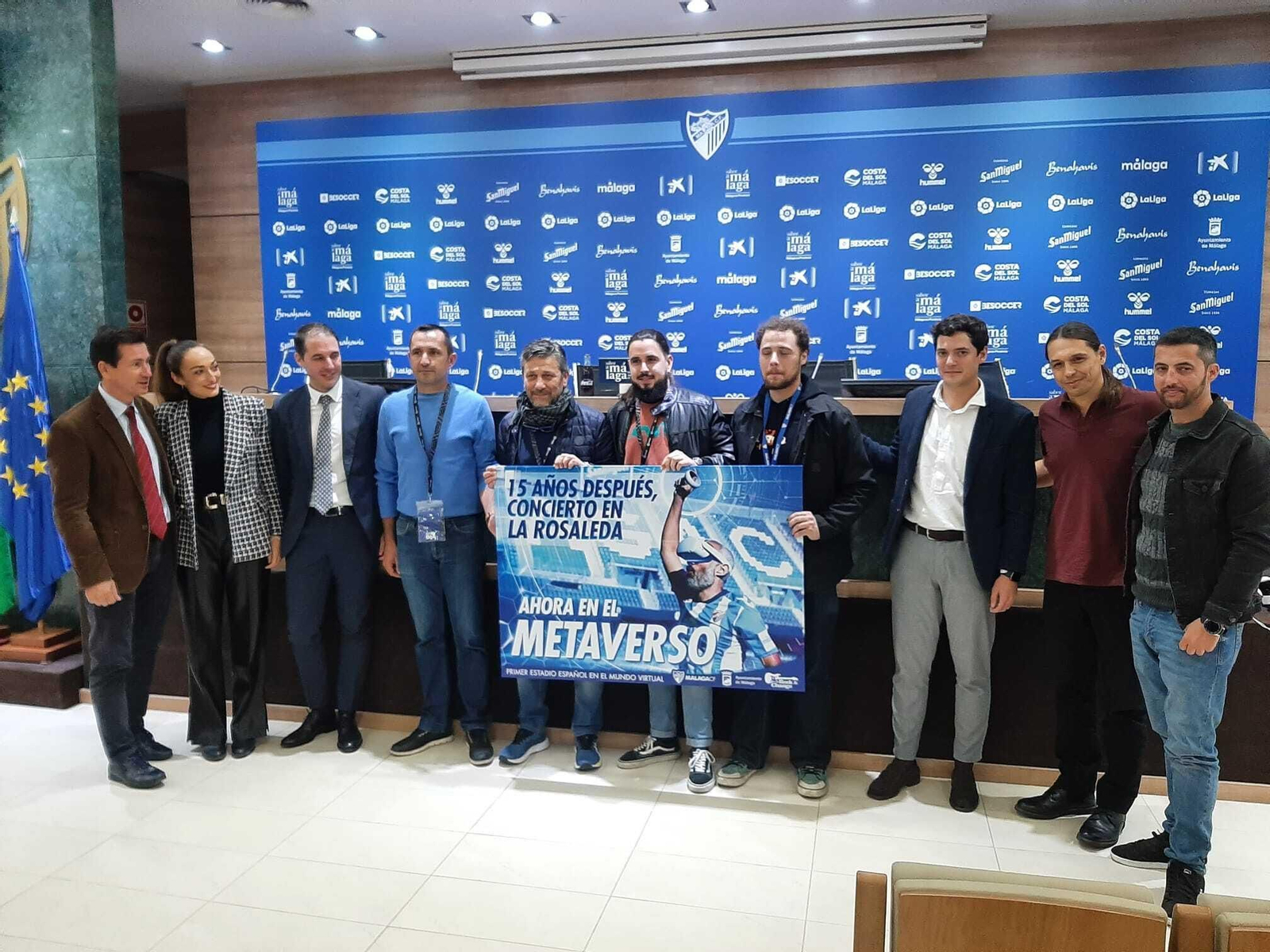 Los creadores posan junto al cartel acompañados de los grupos que actuarán y los representantes de las instituciones.