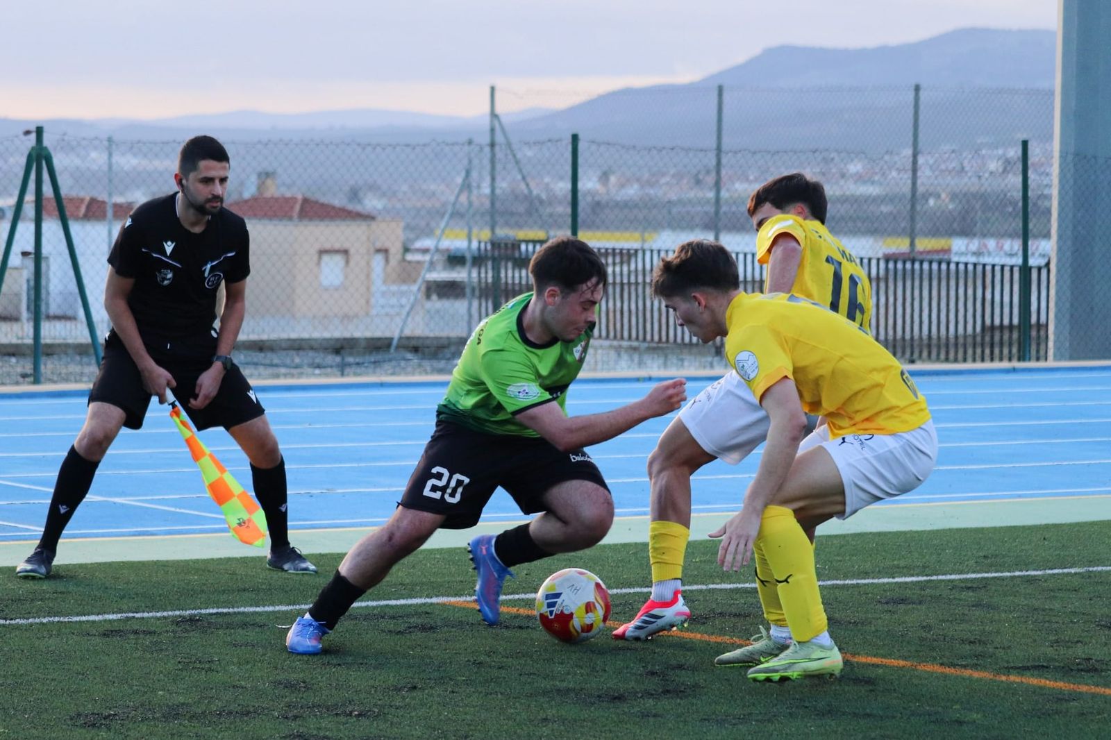 Un jugador del Huétor Vega encarando a dos futbolistas del CF Motril