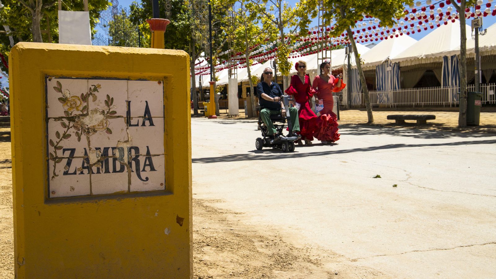 Asistentes a la feria pasan por calle la Zambra