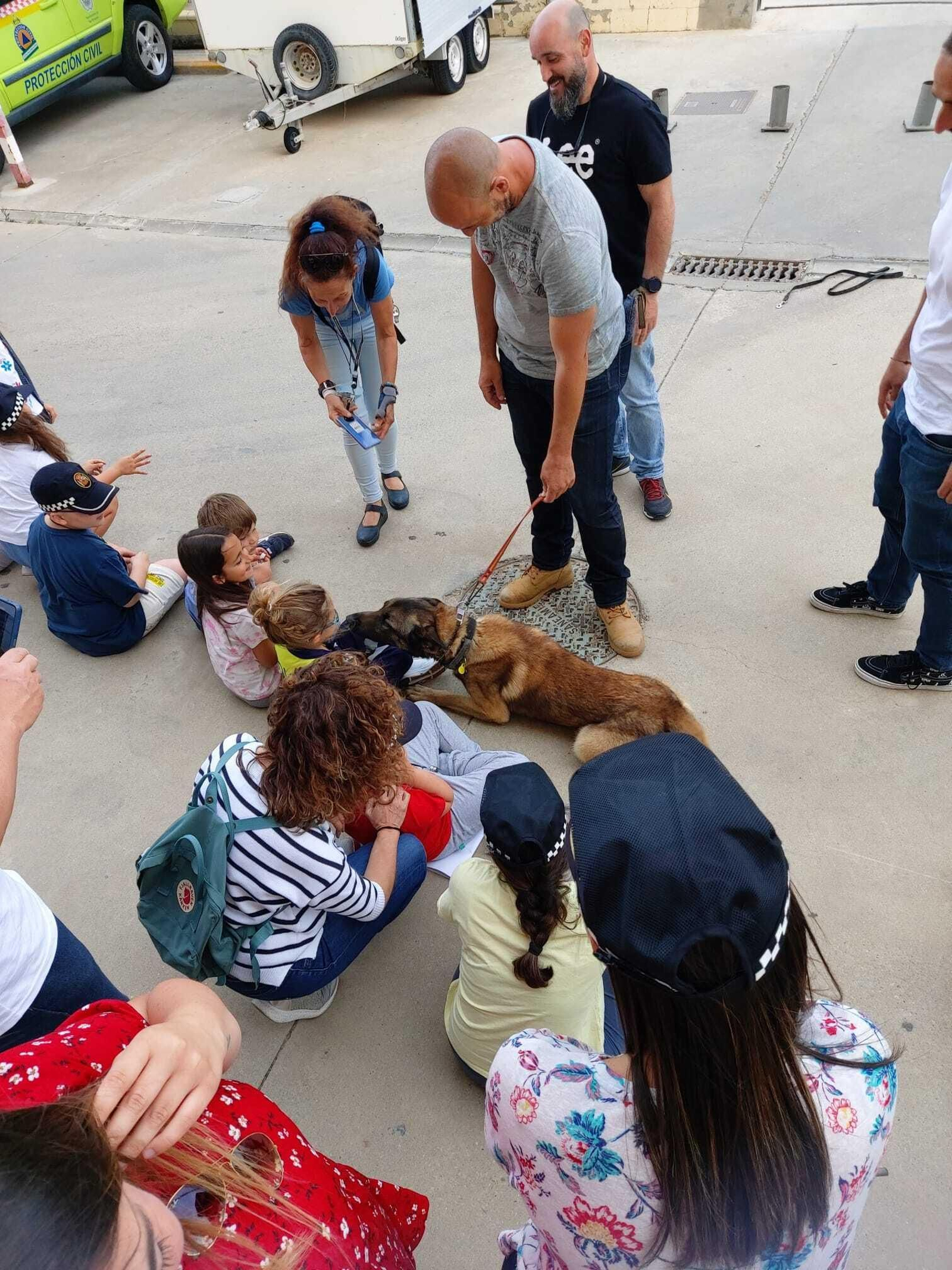 Los menores de la Fundación ONCE acarician a uno de los perros de la Unidad Canina de la Policía Local.