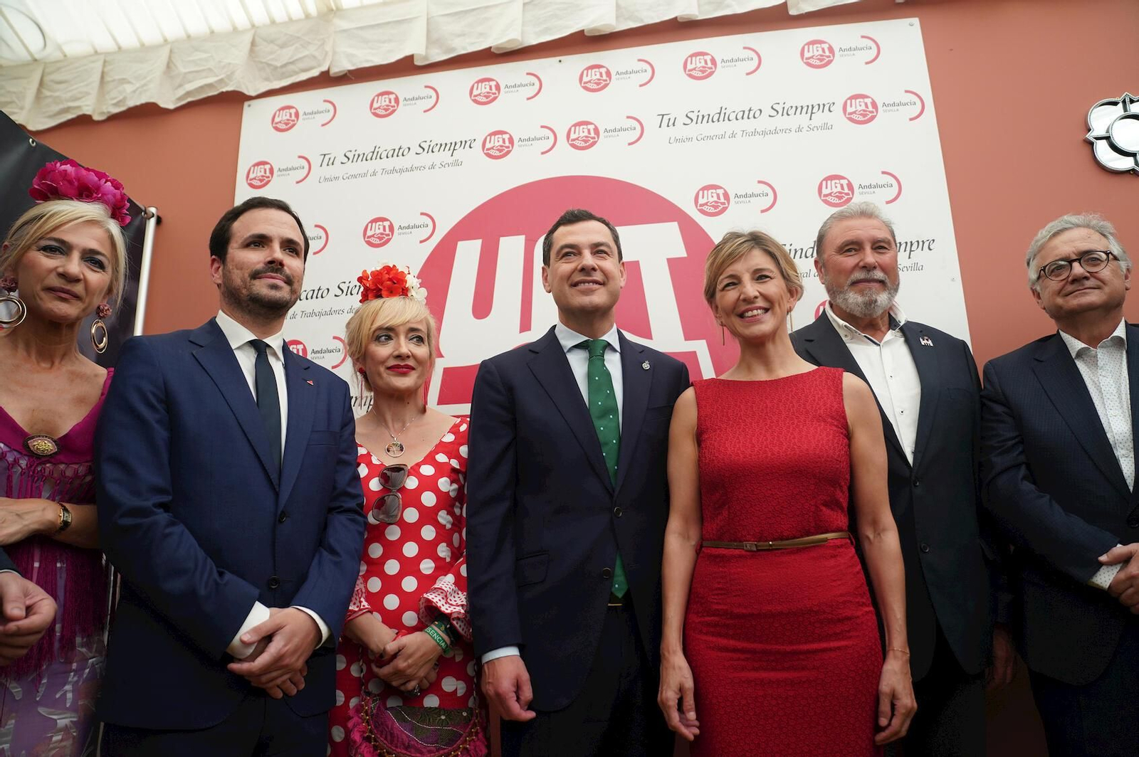 Los ministros Yolanda Díaz y Alberto Garzón, junto a Juanma Moreno, en la caseta de UGT de la Feria de Sevilla del año pasado.