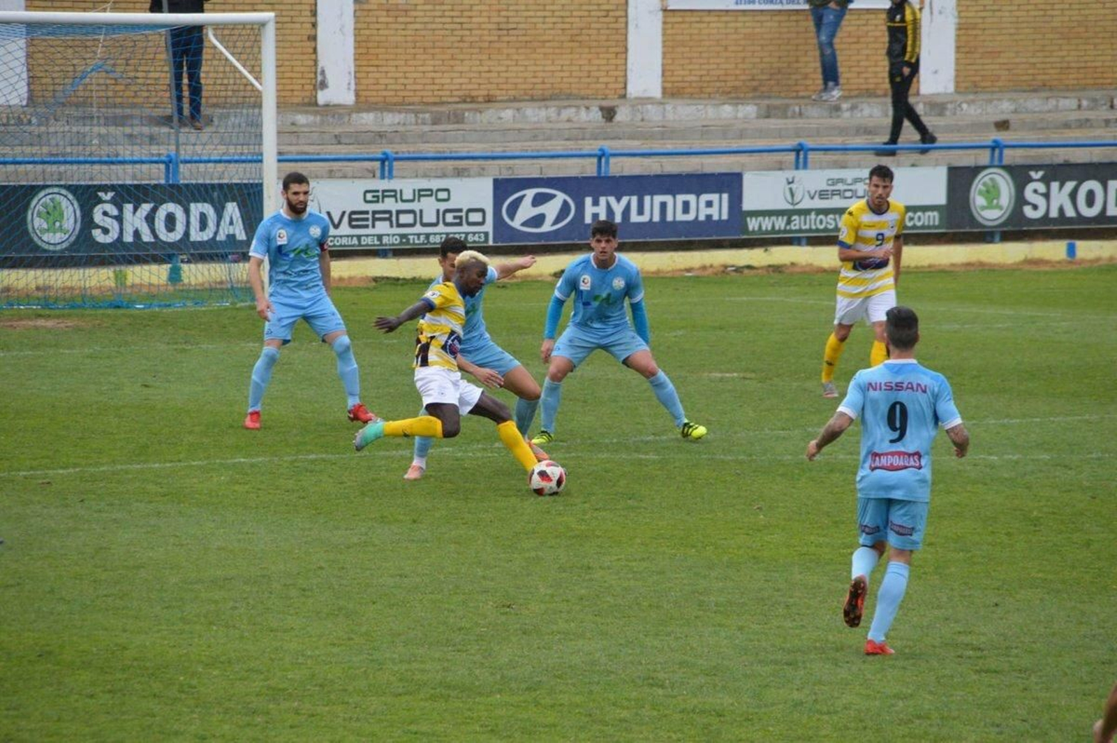 Tres jugadores del Ciudad de Lucena presionan al jugador del Coria Keita.