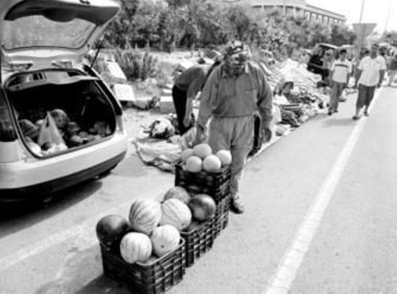 Vendedores ambulantes descargan el material de venta desde sus vehículos particulares.