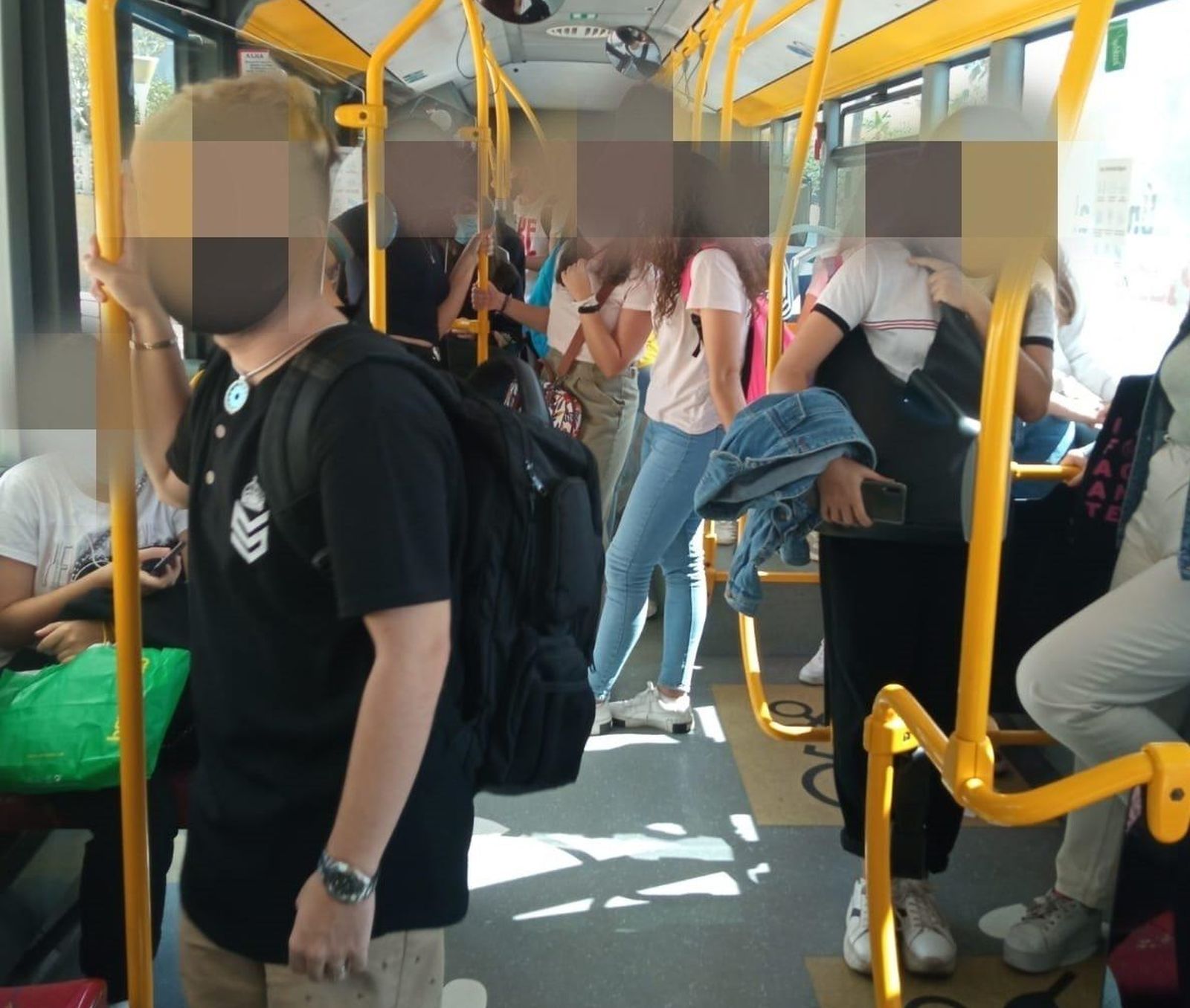 Estudiantes sin la suficiente distancia social en el autobús de la universidad.