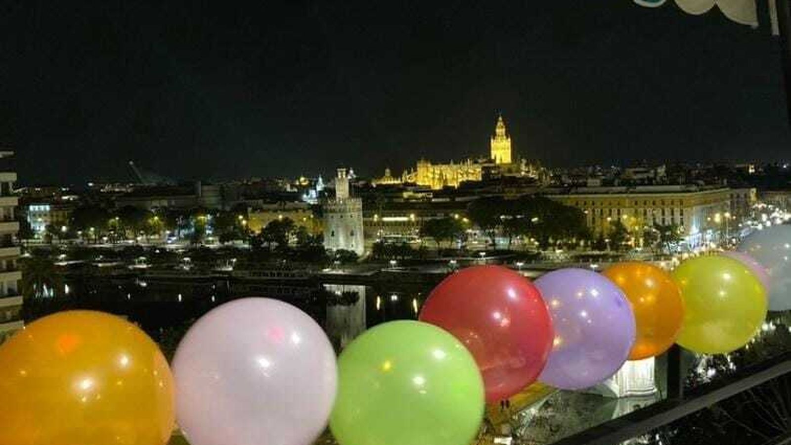 Vista de Sevilla desde un balcón que luce globos por los niños que sufren cáncer.