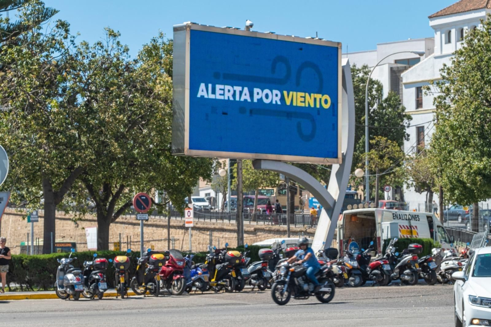 La pantalla led de la plaza de Sevilla avisa de que la ciudad está en alerta amarilla por viento.