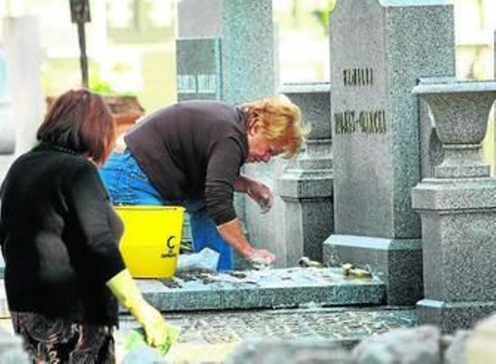 Dos mujeres acuden al cementerio de La Salud para limpiar la tumbas de sus difuntos.