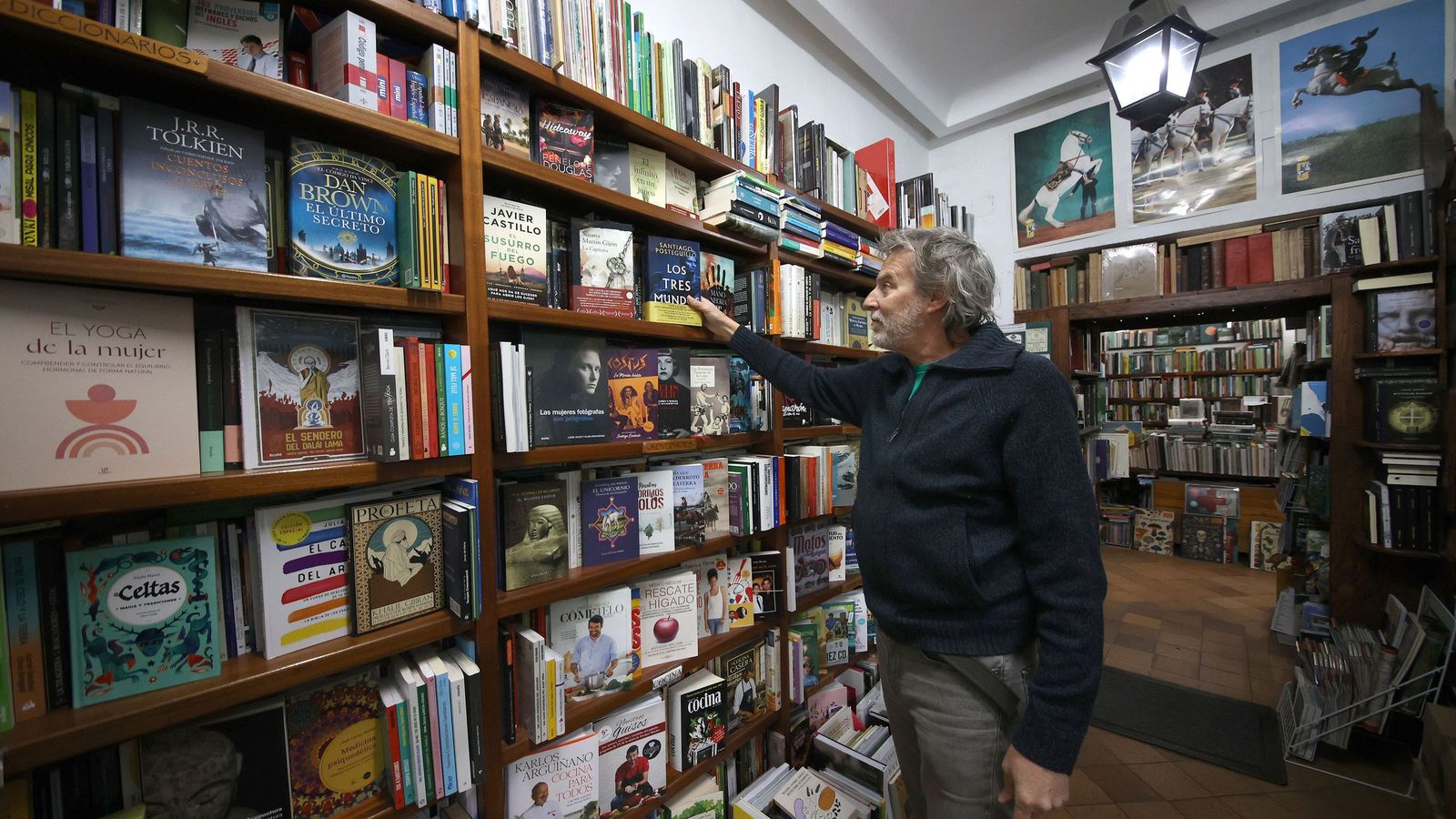 Félix, junto a algunas de las estanterías del negocio.