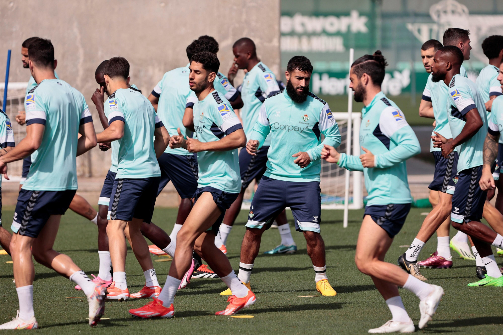 La plantilla del Betis hace ejercicios de calentamiento en la ciudad deportiva.