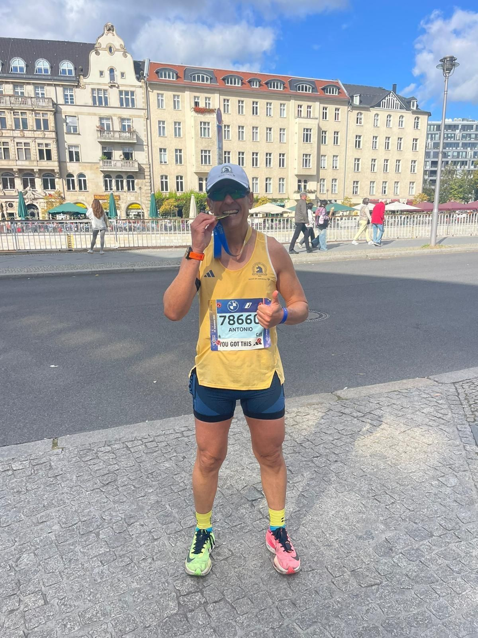 El autor del artículo muerde la medalla tras cruzar la línea de meta en Berlín