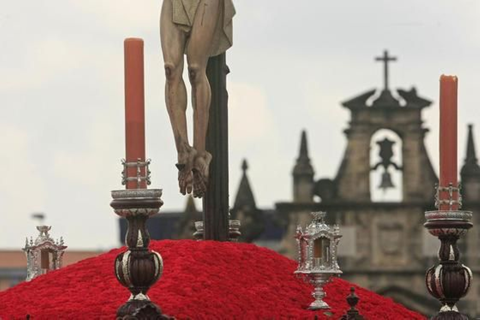 Imagen de los pies del Cristo del Perdón sobre un monte rojo con su sede canónica, la Ermita de Guía, al fondo

Foto: Juan Carlos Toro