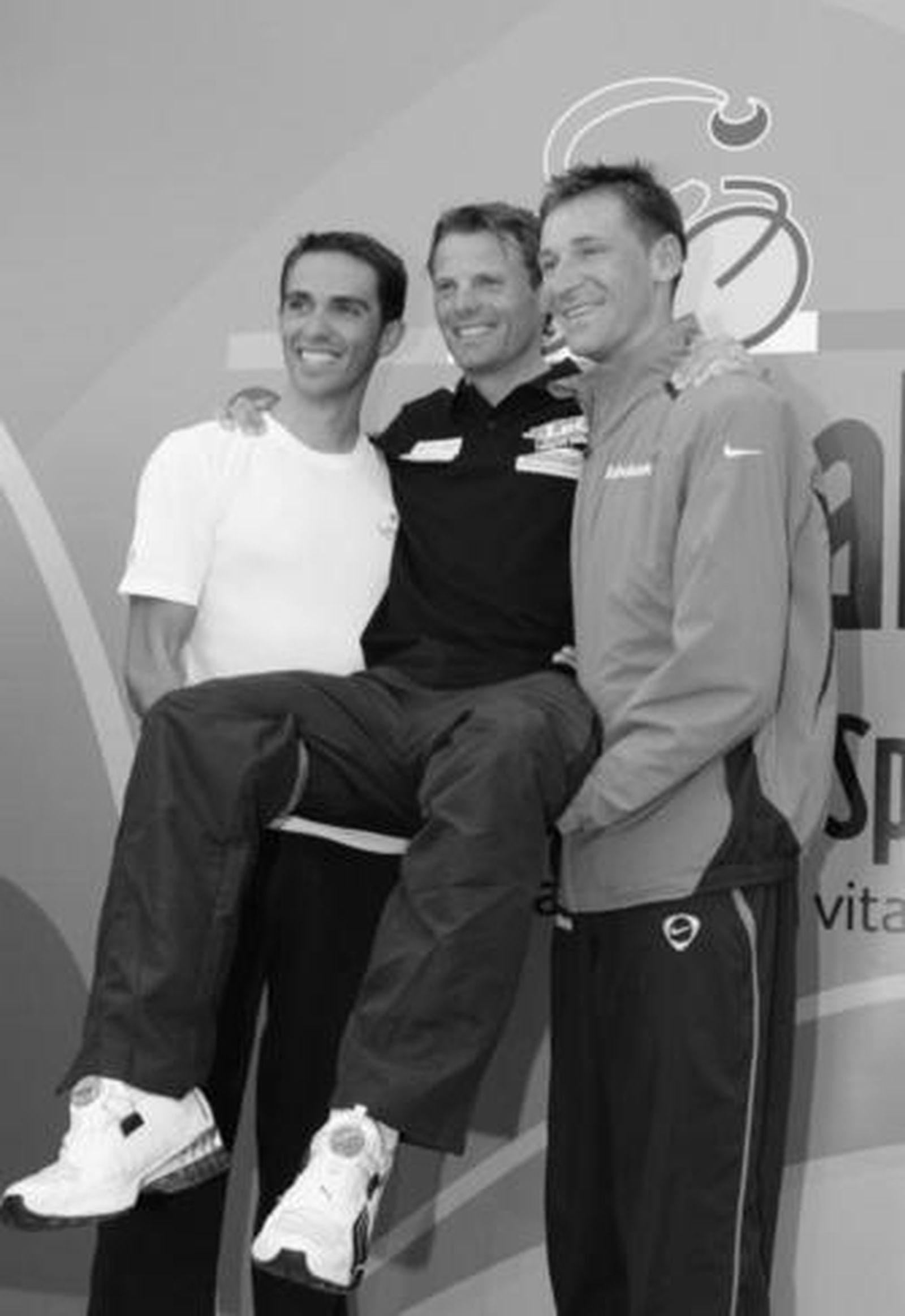 Contador (i) y Menchov (d) cogen en brazos a Di Luca.