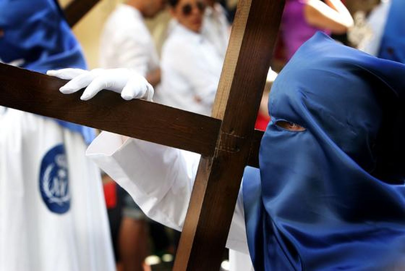Un penitente de la hermandad de la Borriquita porta una cruz tras el paso de misterio.

Foto: Pascual
