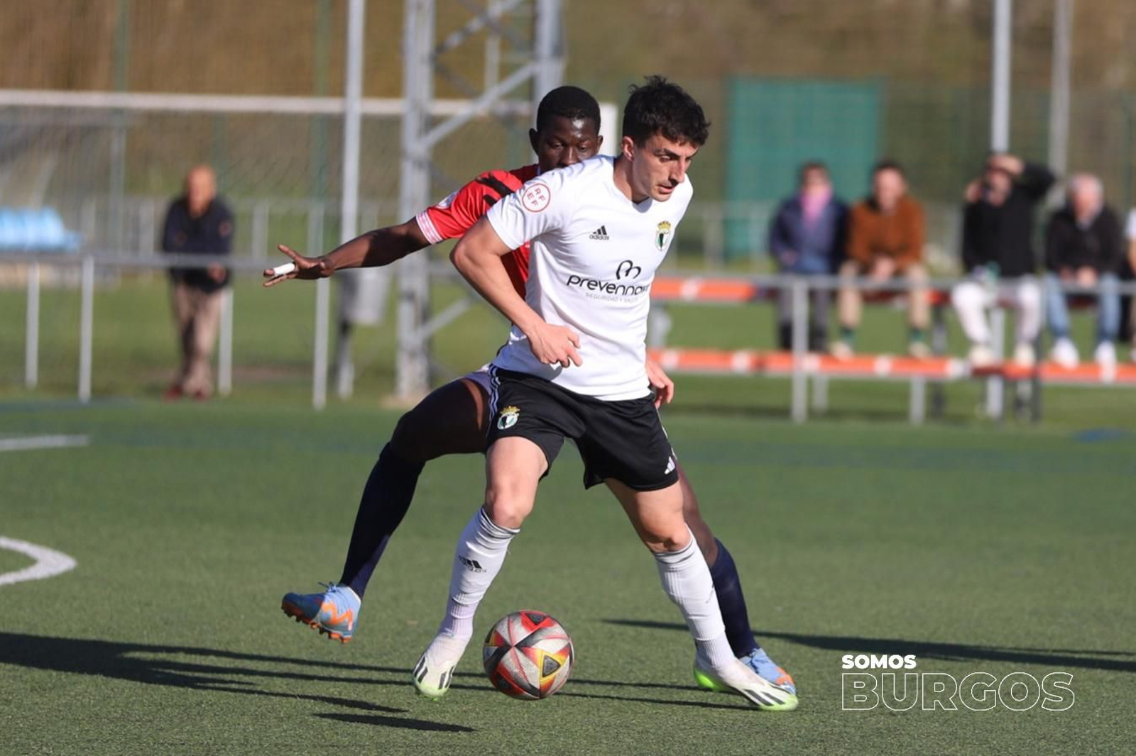 Sergio Fernández protege un balón con la camiseta del Burgos Promesas.