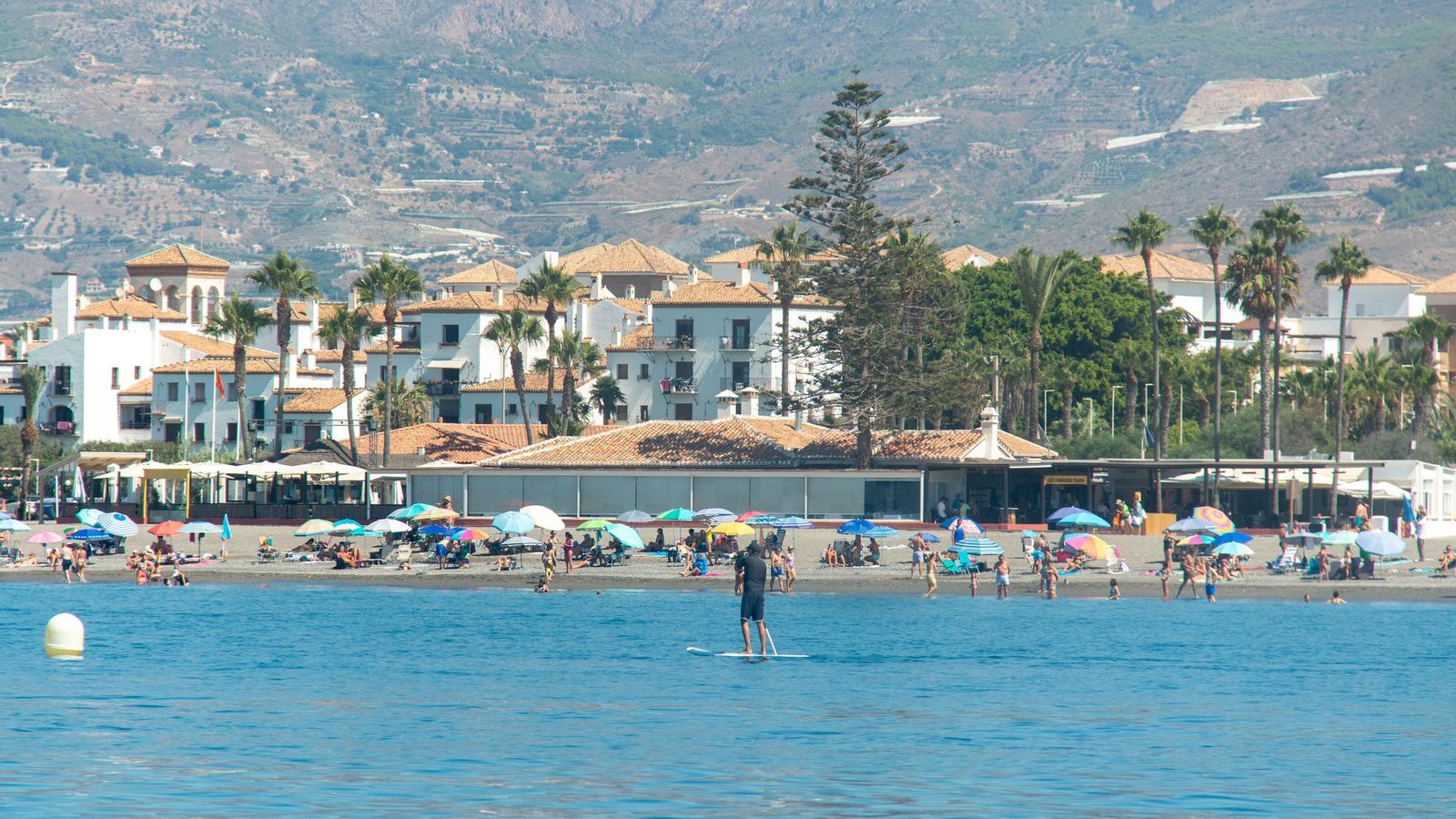 Personas disfrutando del día de playa frente a los Moriscos, en Playa Granada