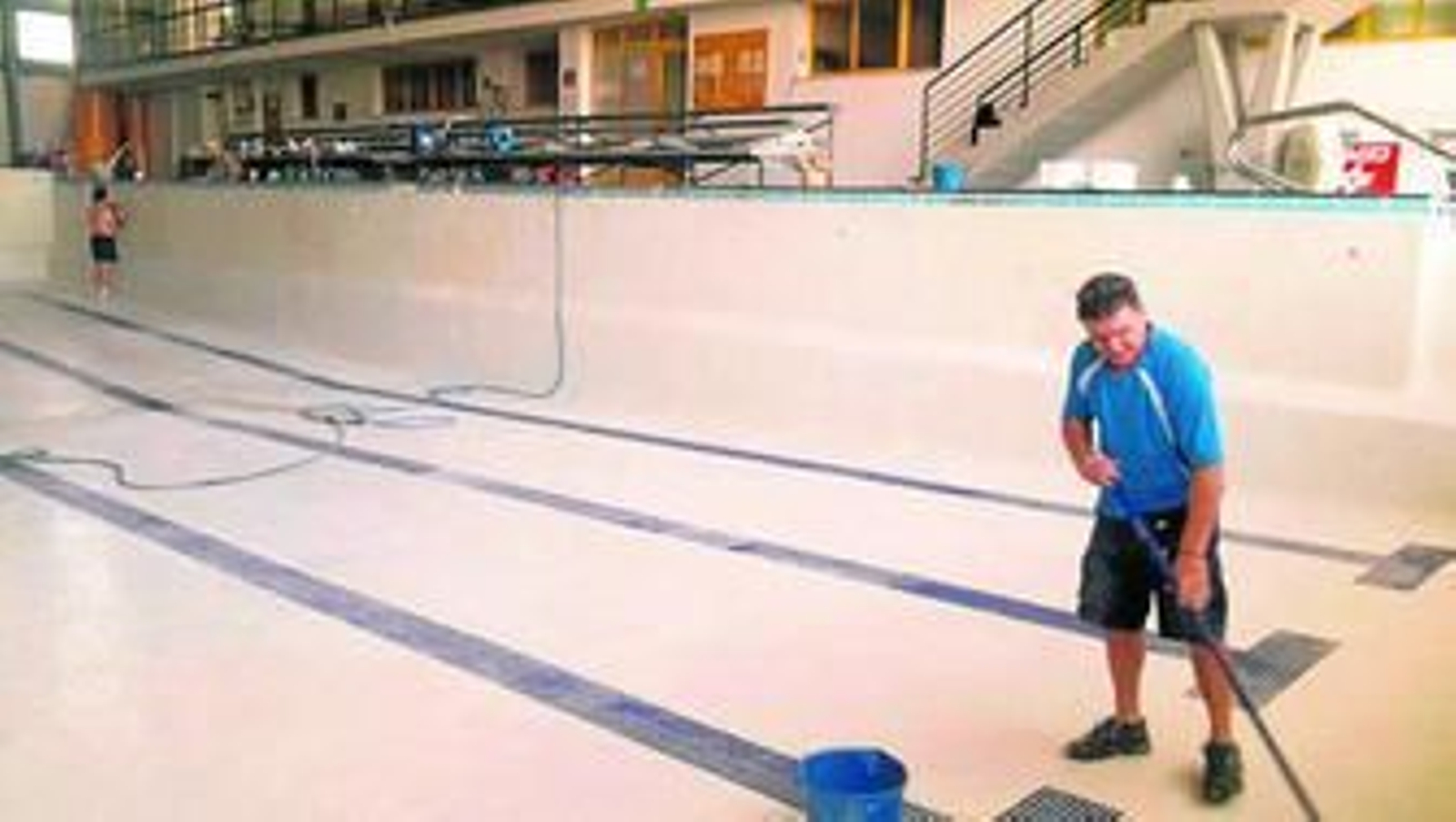 Un operario municipal, efectuando labores de limpieza en la piscina cubierta José Laguillo.