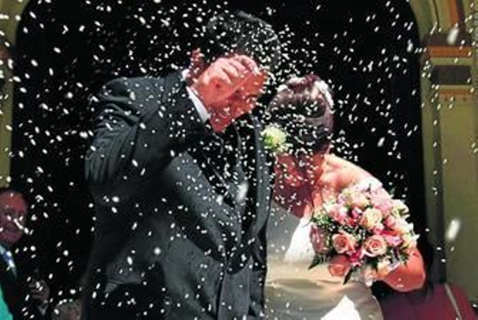 Una pareja recibe la tradicional lluvia de arroz a la salida de su boda en el Ayuntamiento de Málaga.