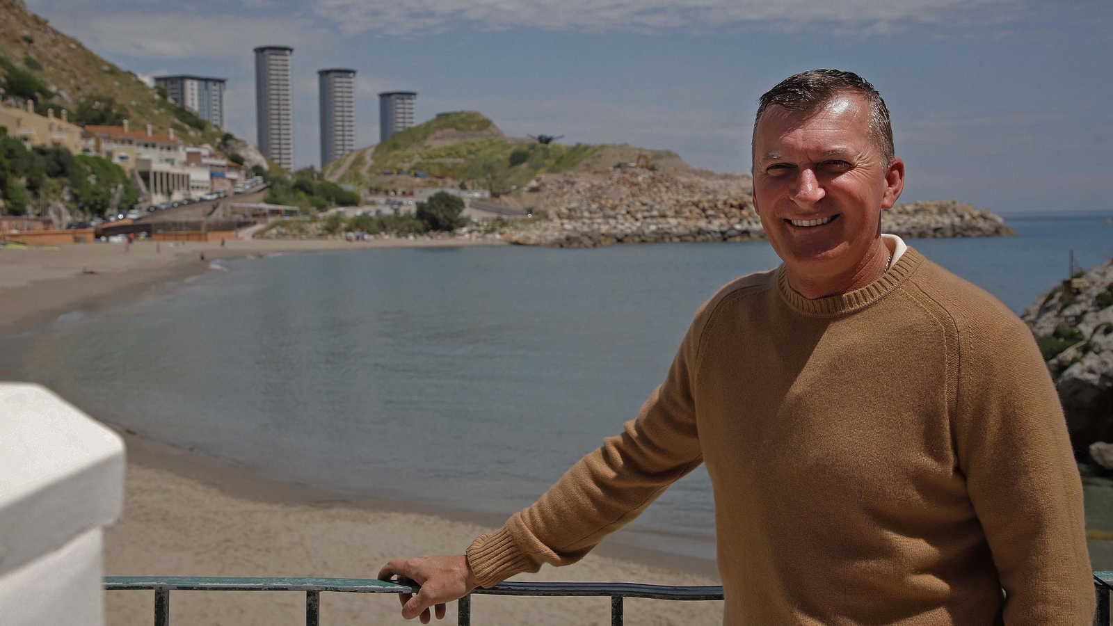 Darren McComb, en la playa gibraltareña de la Caleta. Tras él, la montaña de escombros sobre la que se alzará parte del Eastside Project. Al fondo, las torres Hassan, construidas también en terreno ganado al mar.