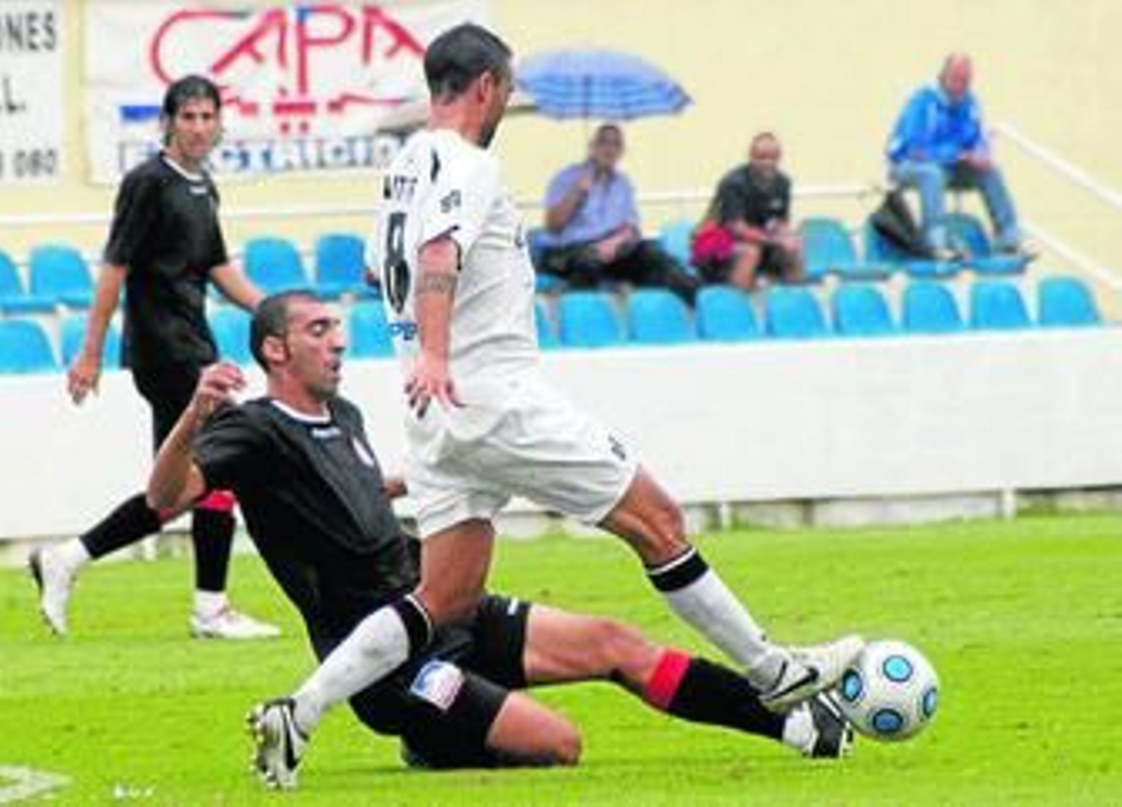 Álvaro Cámara se lanza a los pies de Aitor para impedir que avance con el balón.