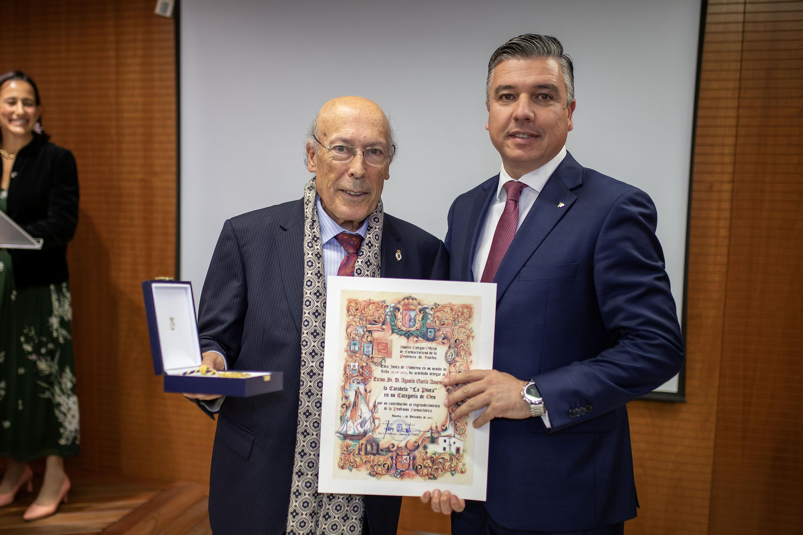 García Asuero recibe el reconocimiento de manos del presidente del Colegio de Farmacéuticos de Huelva, Jorge Juan García.