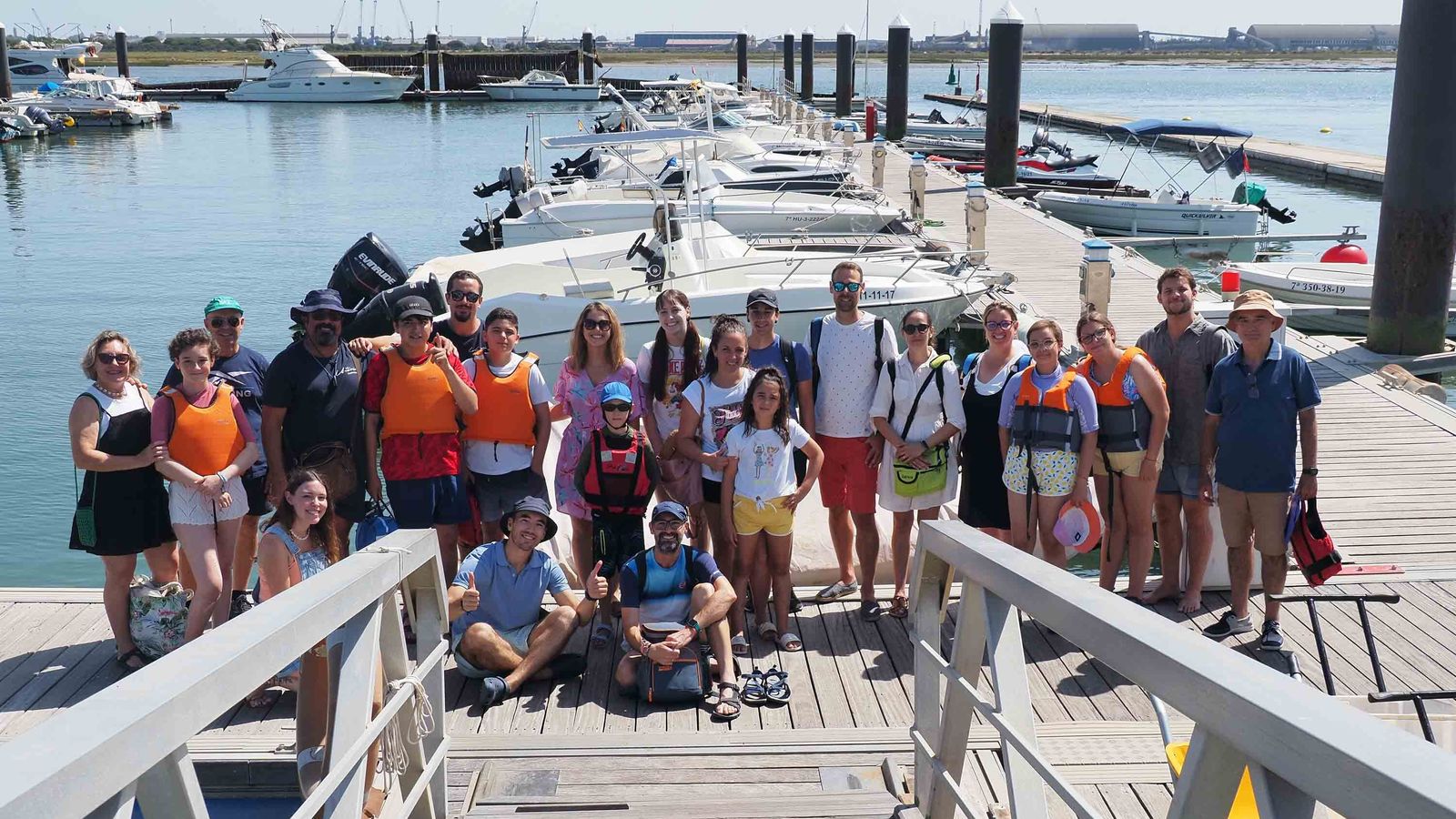Foto de familia de los menores con sus familias, y de los organizadores de la actividad, antes de zarpar en Punta Umbría