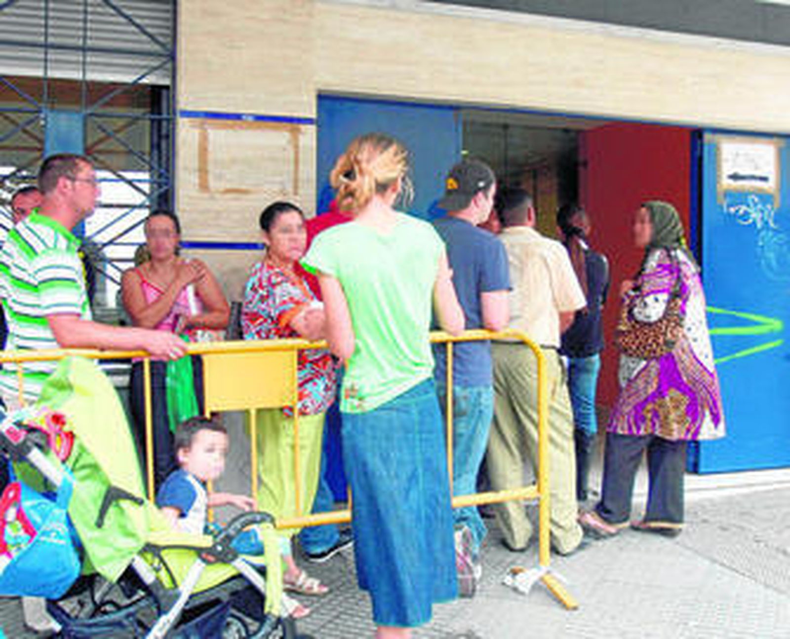 Inmigrantes haciendo cola en la Oficina de Extranjeros de Huelva.