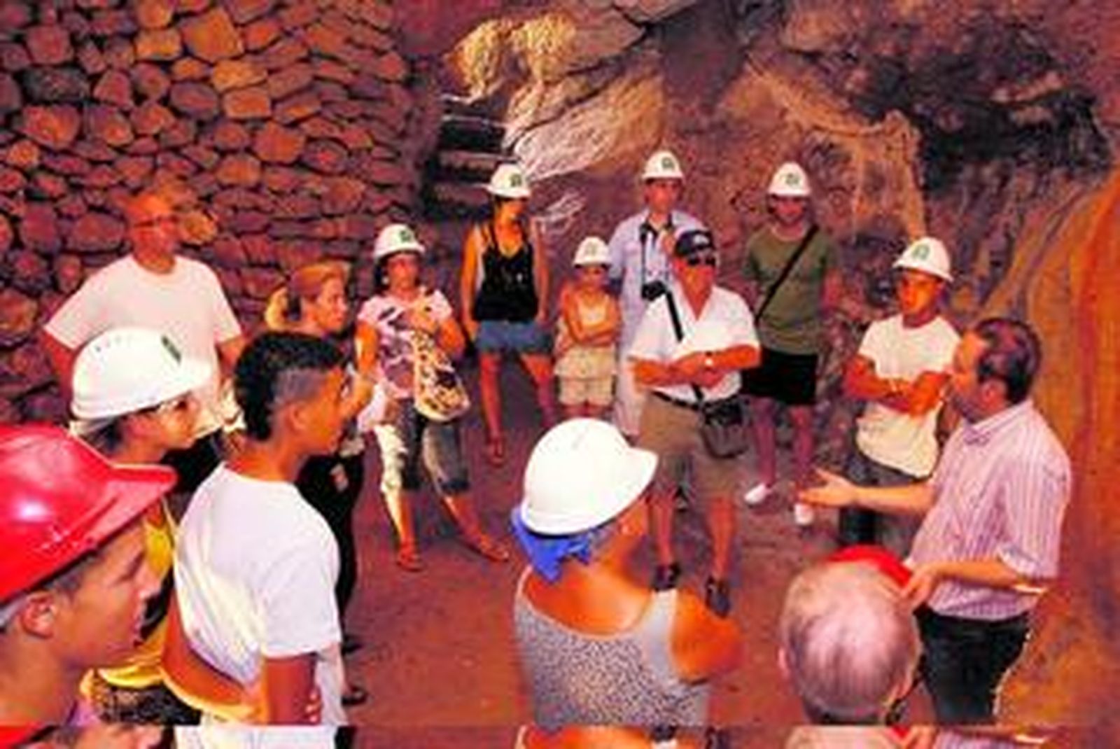 El público contemplando la boca de entrada a un silo en el tercer recinto de la Alcazaba.