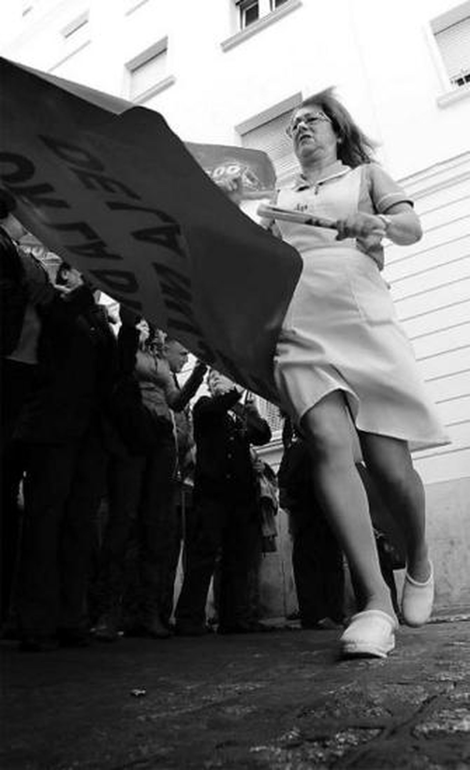 Una enfermera junto a la pancarta de la concentración.