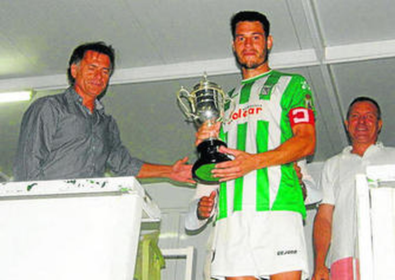 Jose, capitán verdiblanco, recoge el trofeo en disputa.