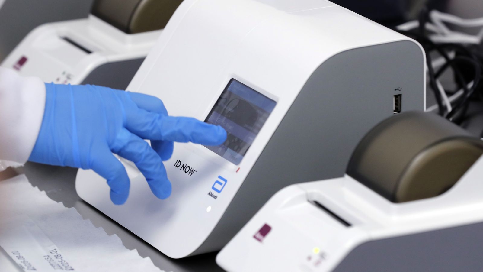 Una especialista opera una maquina para detección de COVID-19 en el laboratorio Synlab en Colombia.