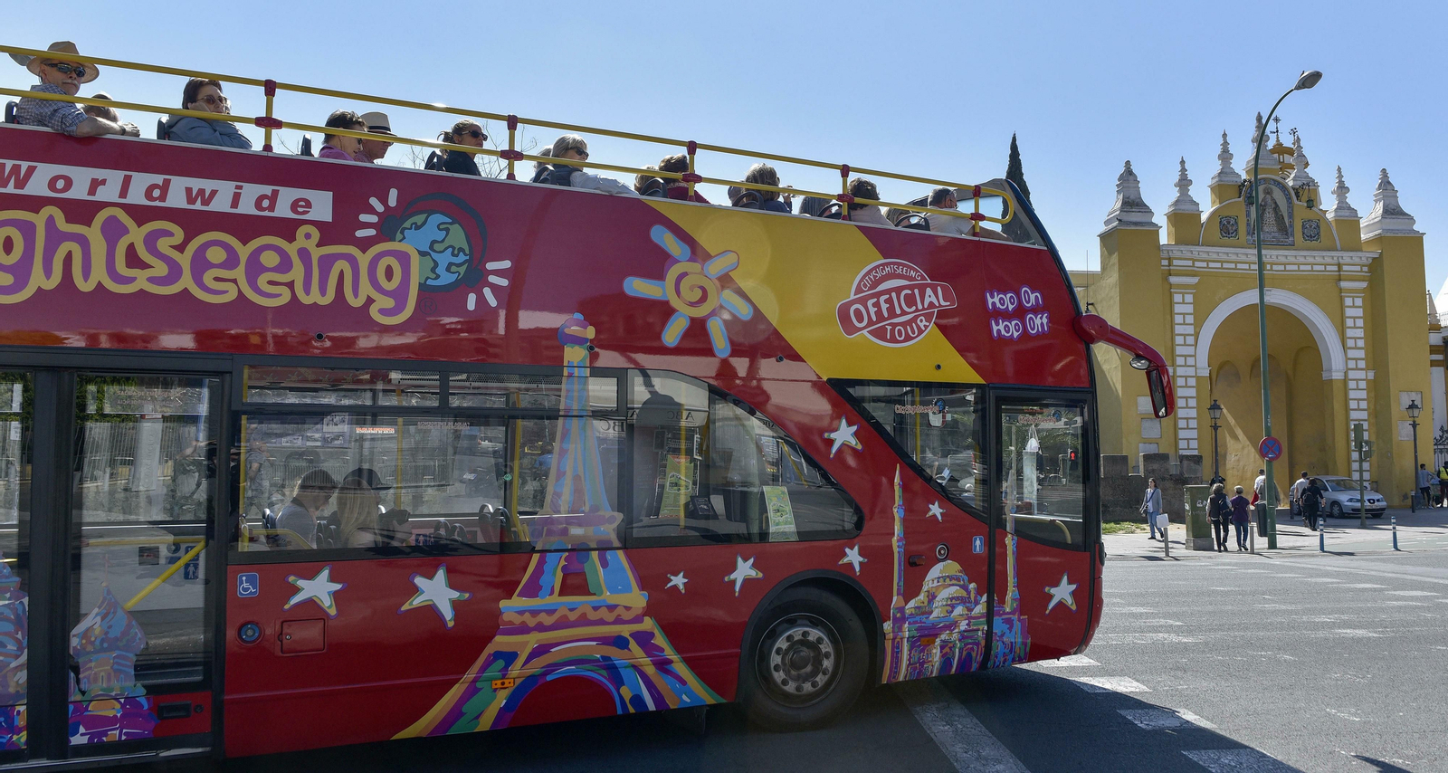 Un autobús turístico pasa por delante de la Muralla de la Macarena.