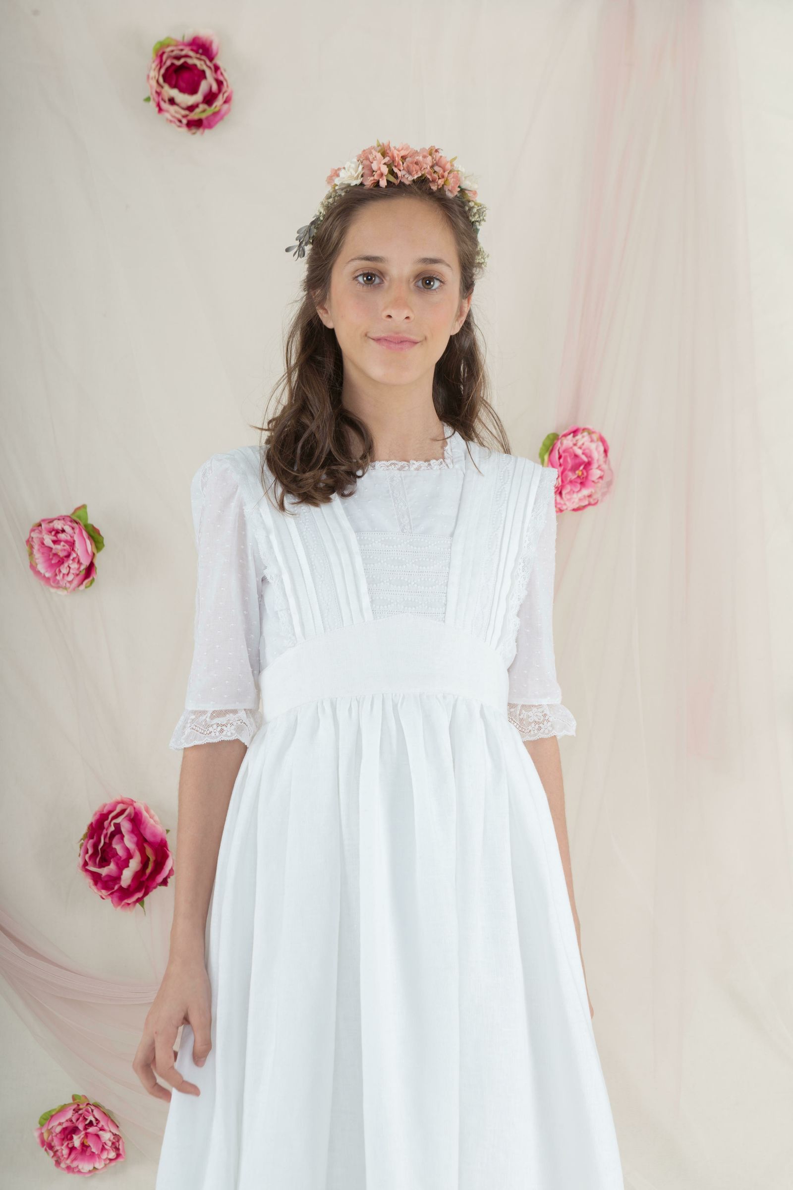 Modelo de inspiración victoriana, de batista con plumeti, jaretas y encaje.