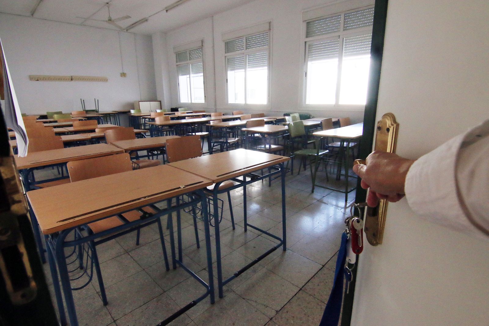 Un bedel abre la puerta de una de las aulas de un colegio.
