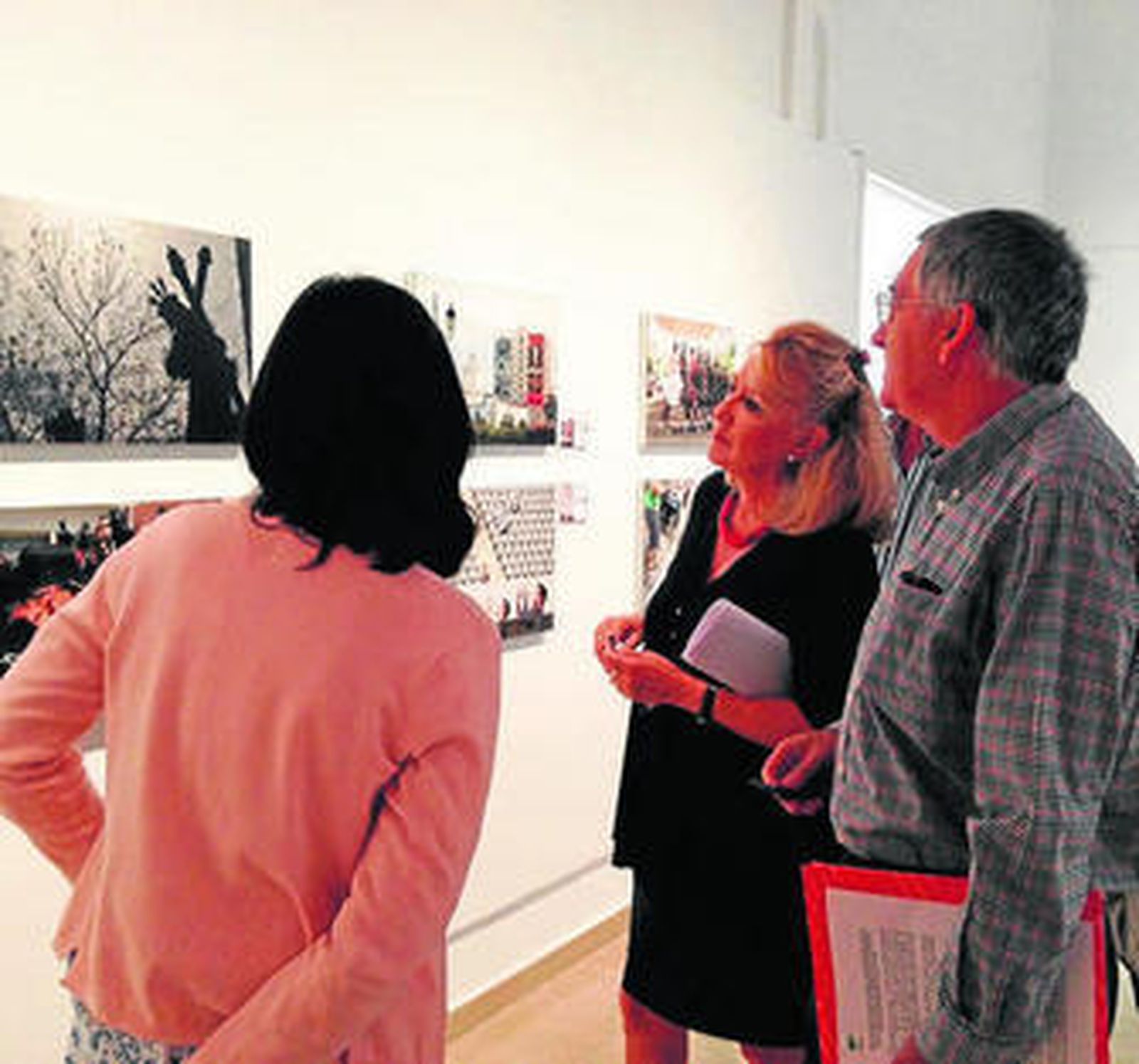 Visitantes observan la exposición en el Museo Joaquín Peinado.