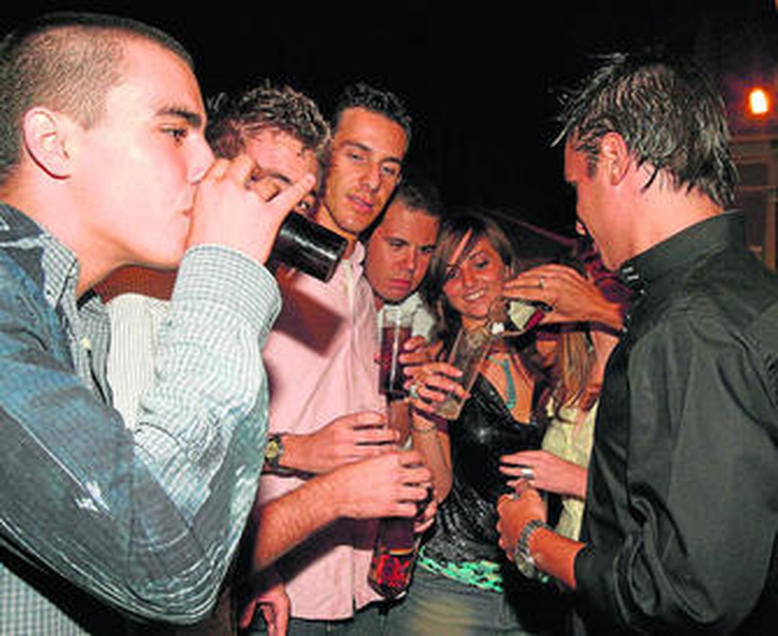 Varios jóvenes hacen 'botellón' en plena calle.