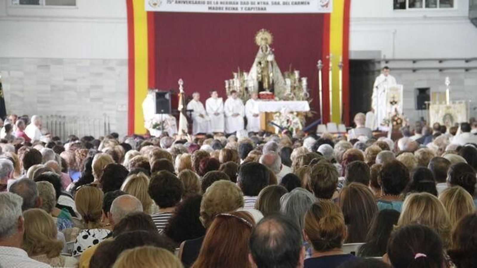 Cientos de devotos de la Virgen del Carmen durante la eucaristía que se oficia en la lonja pesquera
