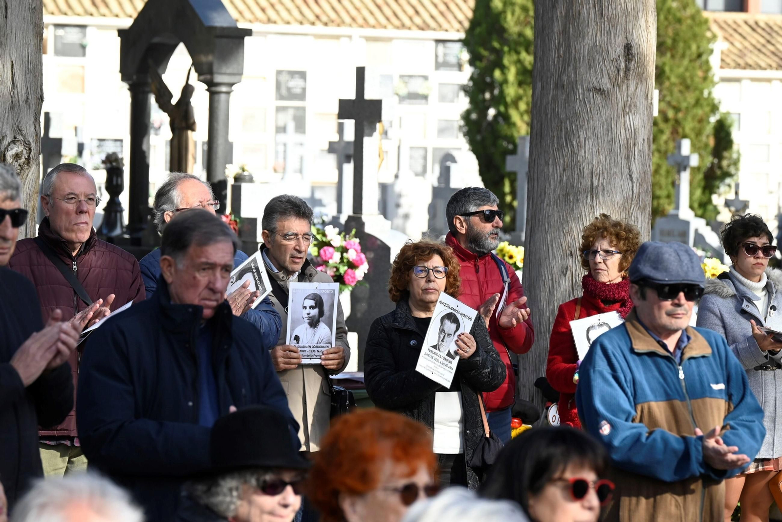 Varias personas sostienen fotos de las víctimas en el cementerio de la Salud de Córdoba.