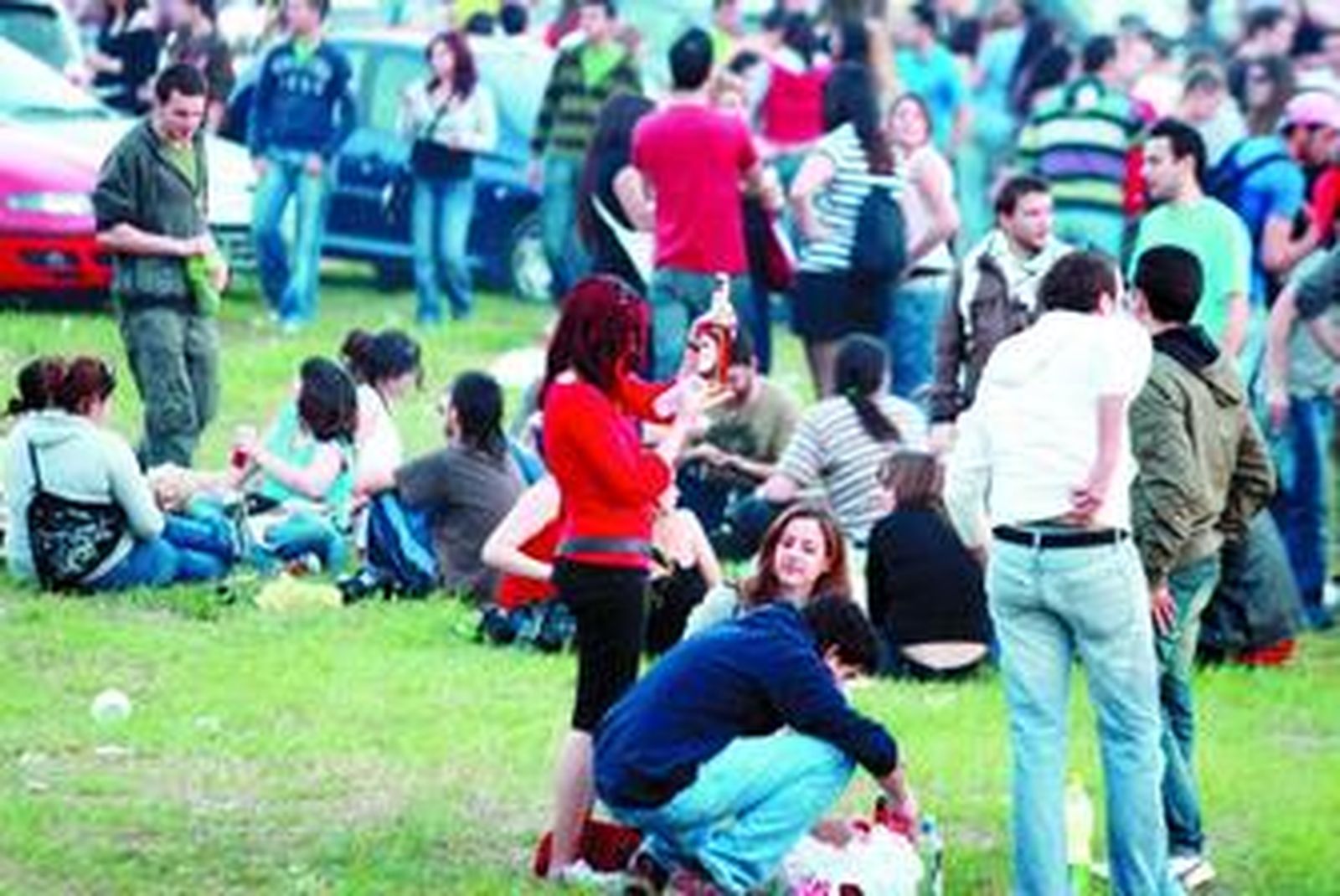 Varios jóvenes hacen 'botellón' con sus amigos en un parque.