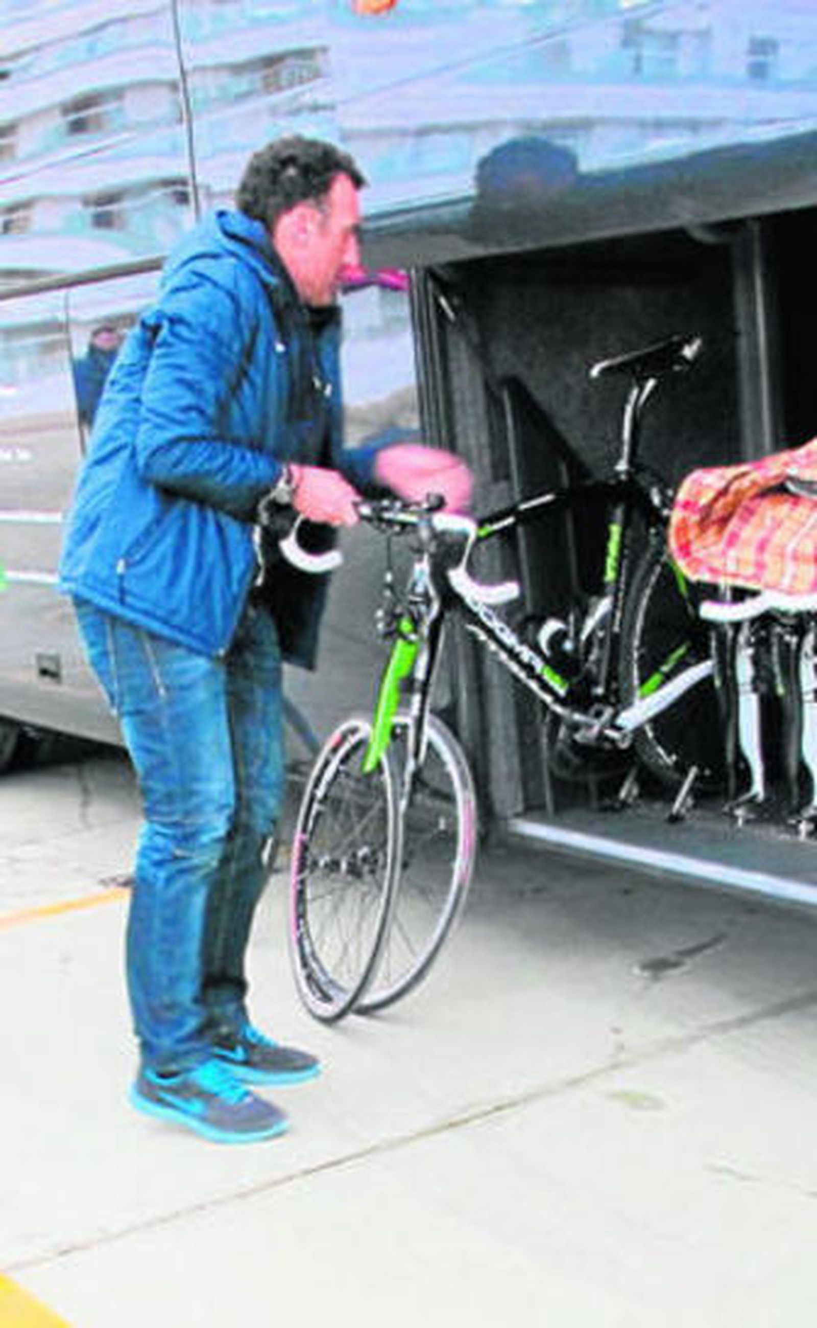 Un mecánico saca una bicicleta del autocar.