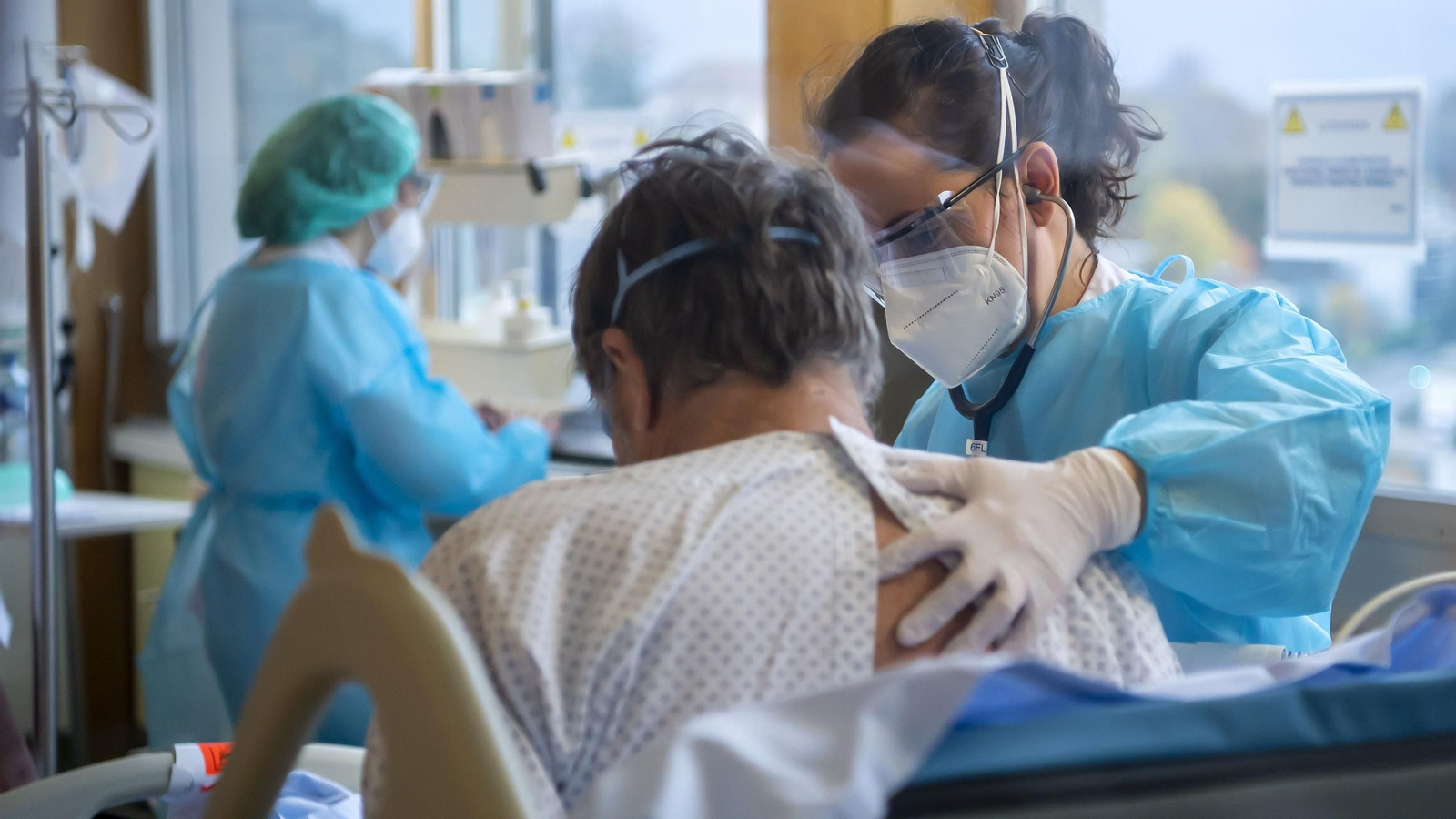 Una sanitaria ayuda a un paciente de Covid