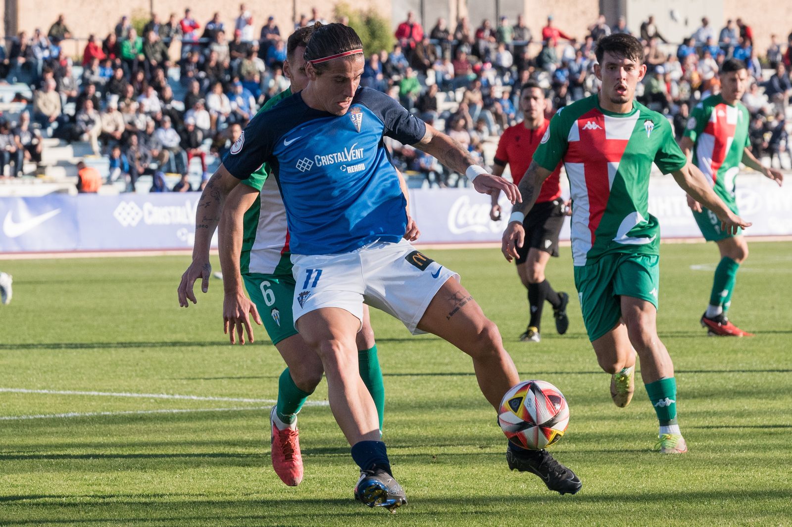Dani Aquino protege el esférico ante la presión de dos adversarios.