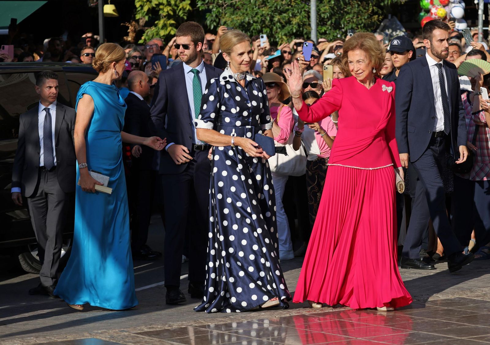Doña Sofía saluda a los atenienses a su llegada a la ceremonia religiosa de la boda de su sobrina Teodora, acompañada de tres nietos y de sus hijas Elena y Cristina