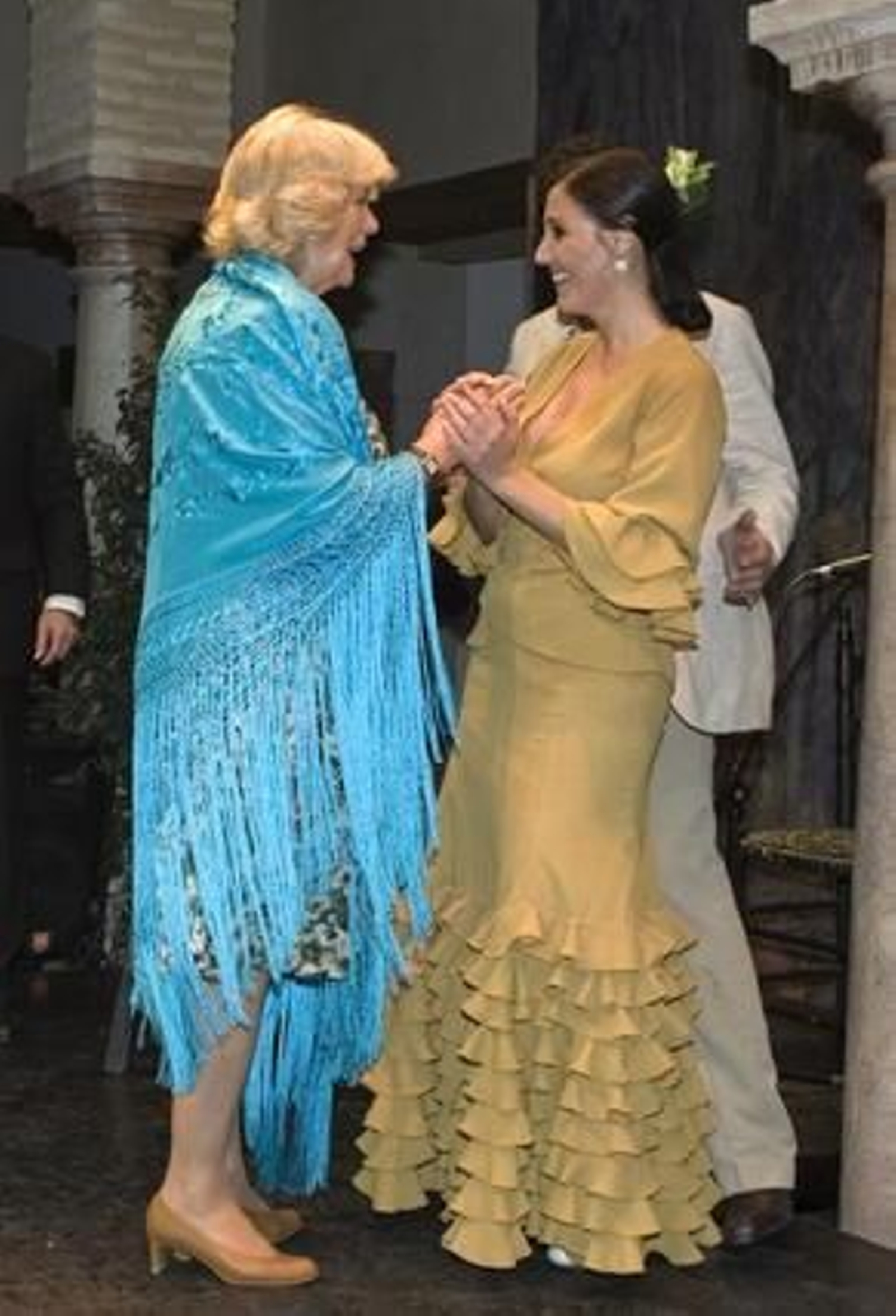 La Duquesa de Cornualles se prueba un mantón azul mientras conversa con la bailaroa Susana Casas.

Foto: Juan Ferreras (EFE)