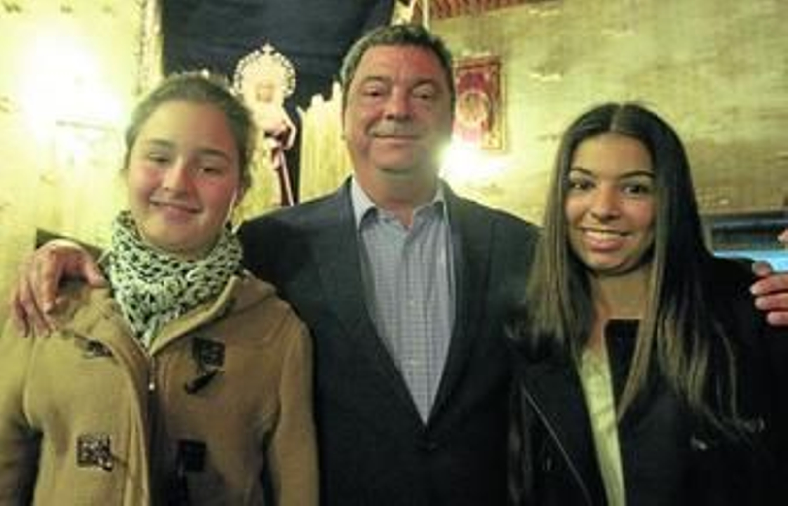 Ignacio Flores, con sus hijas Cristina y María, en la parroquia de San Ignacio de Loyola con la Virgen del Rosario al fondo.