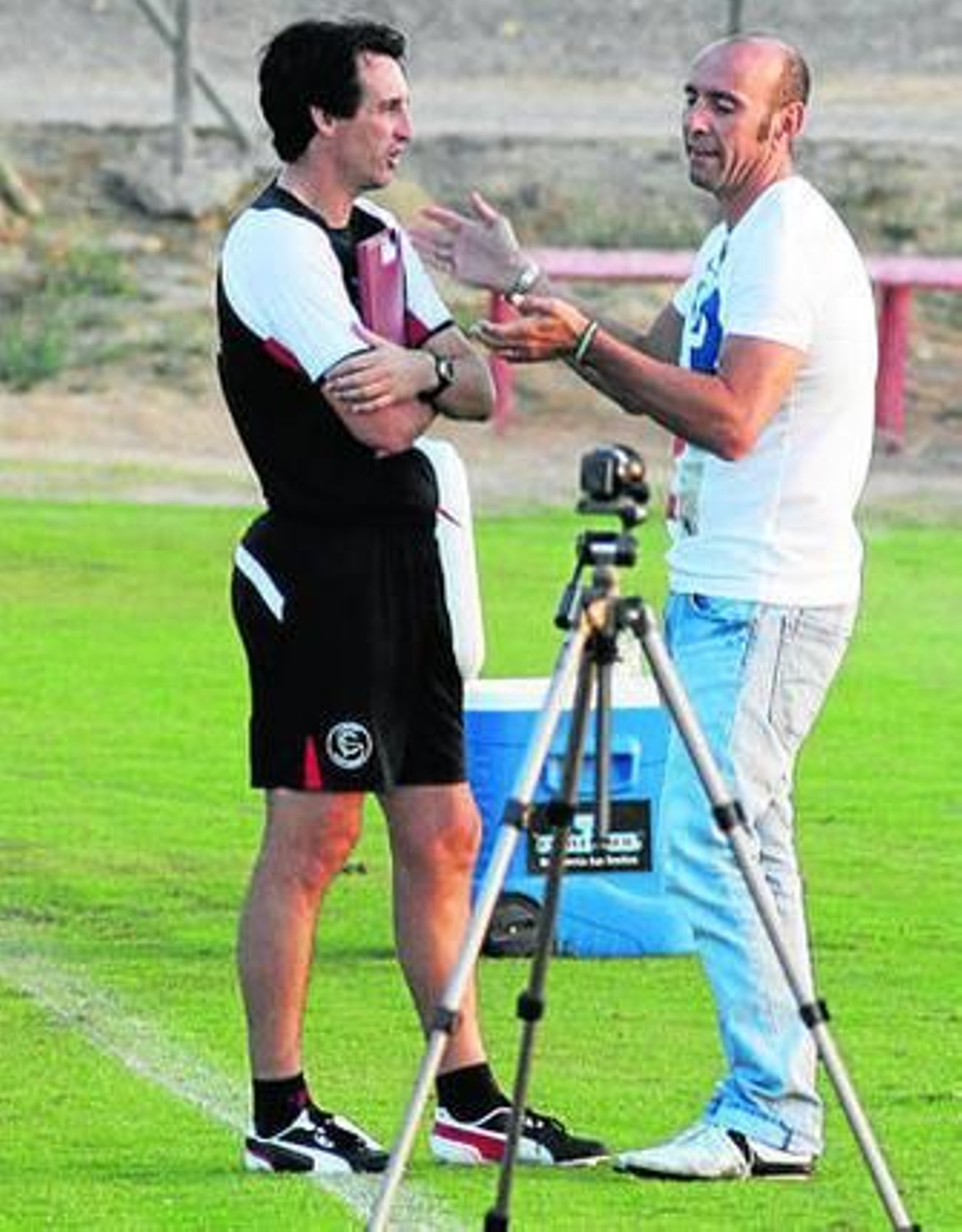 Unai Emery, en charla con Monchi a pie de césped.