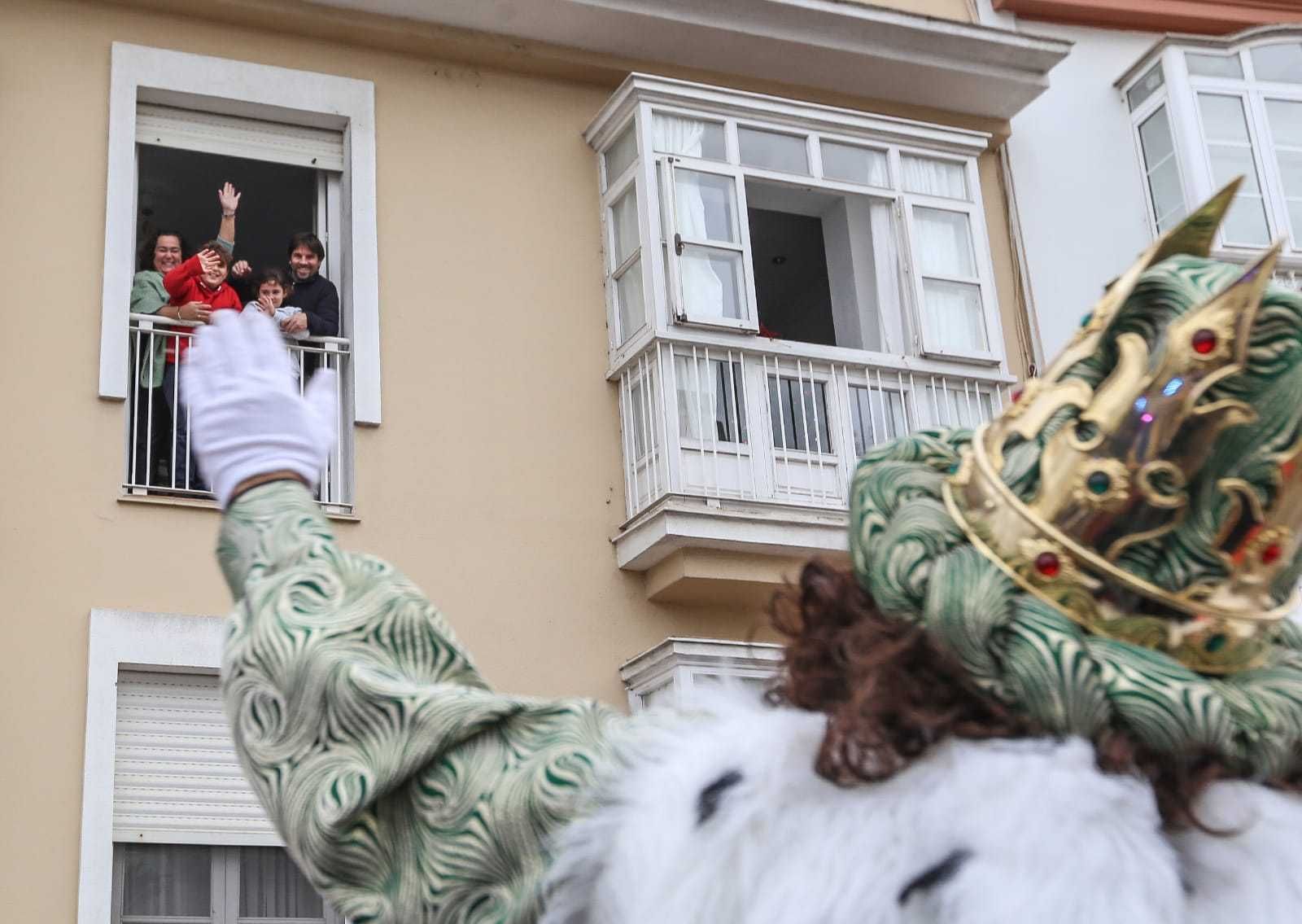 Las familias saludan desde los balcones en la cabalgata de la pandemia, año 2021