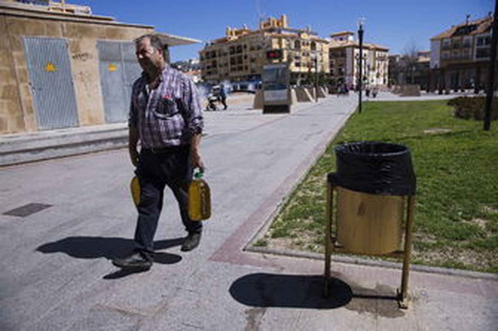 Un hombre pasa junto a una de las papeleras pintadas de dorado.